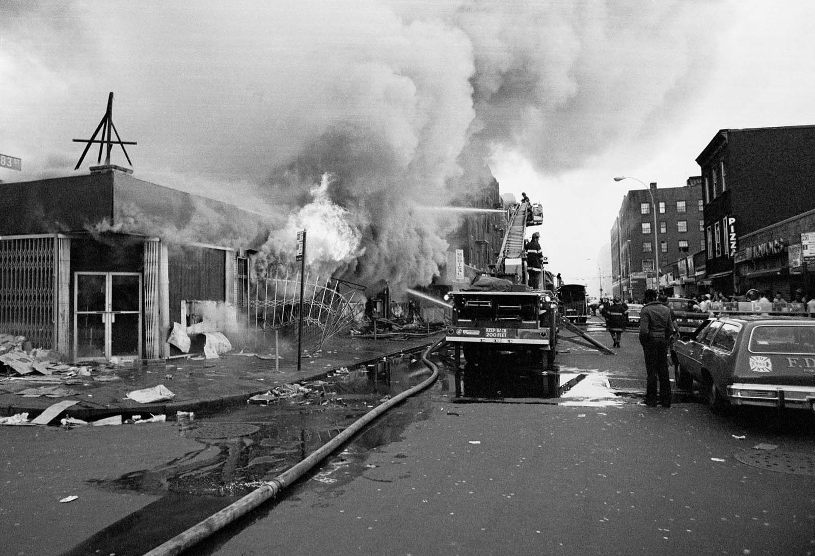 Firemen battle flames at a store in the Bronx borough of New York, one of many fires that broke out during the massive power failure that crippled the city for more than 24 hours, seen July 14, 1977. Firemen answered 1,500 alarms, 400 of which were actual fires. Forty of the fires were termed serious.