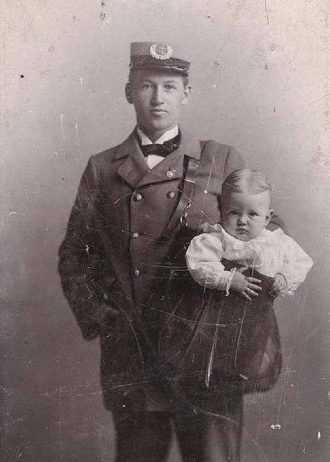 Another mailman posing with a baby in his bag.