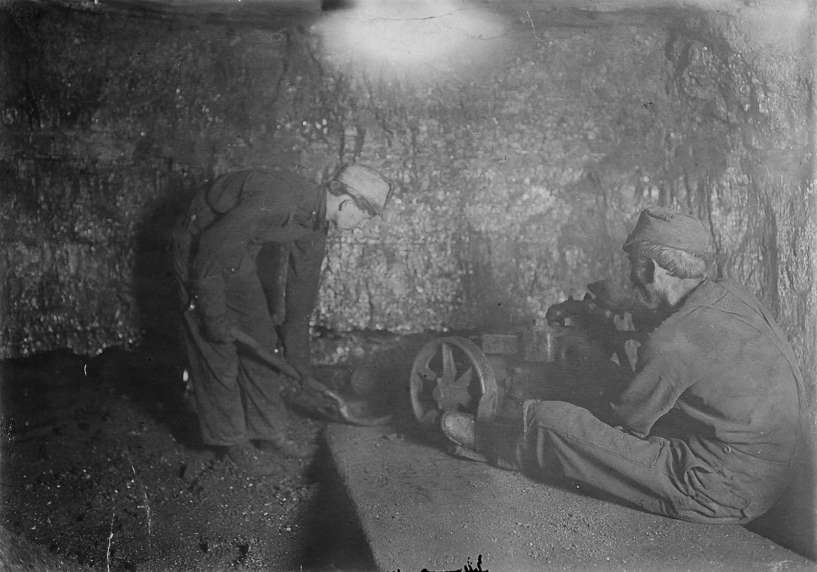 A boy shovels loose rock in a mine in Red Star, West Virginia. 1908.