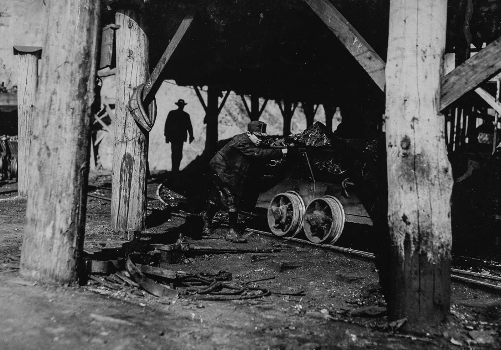 James O'Dell pushes a coal cart outside a mine in Coal Creek, Tennessee. 1910.