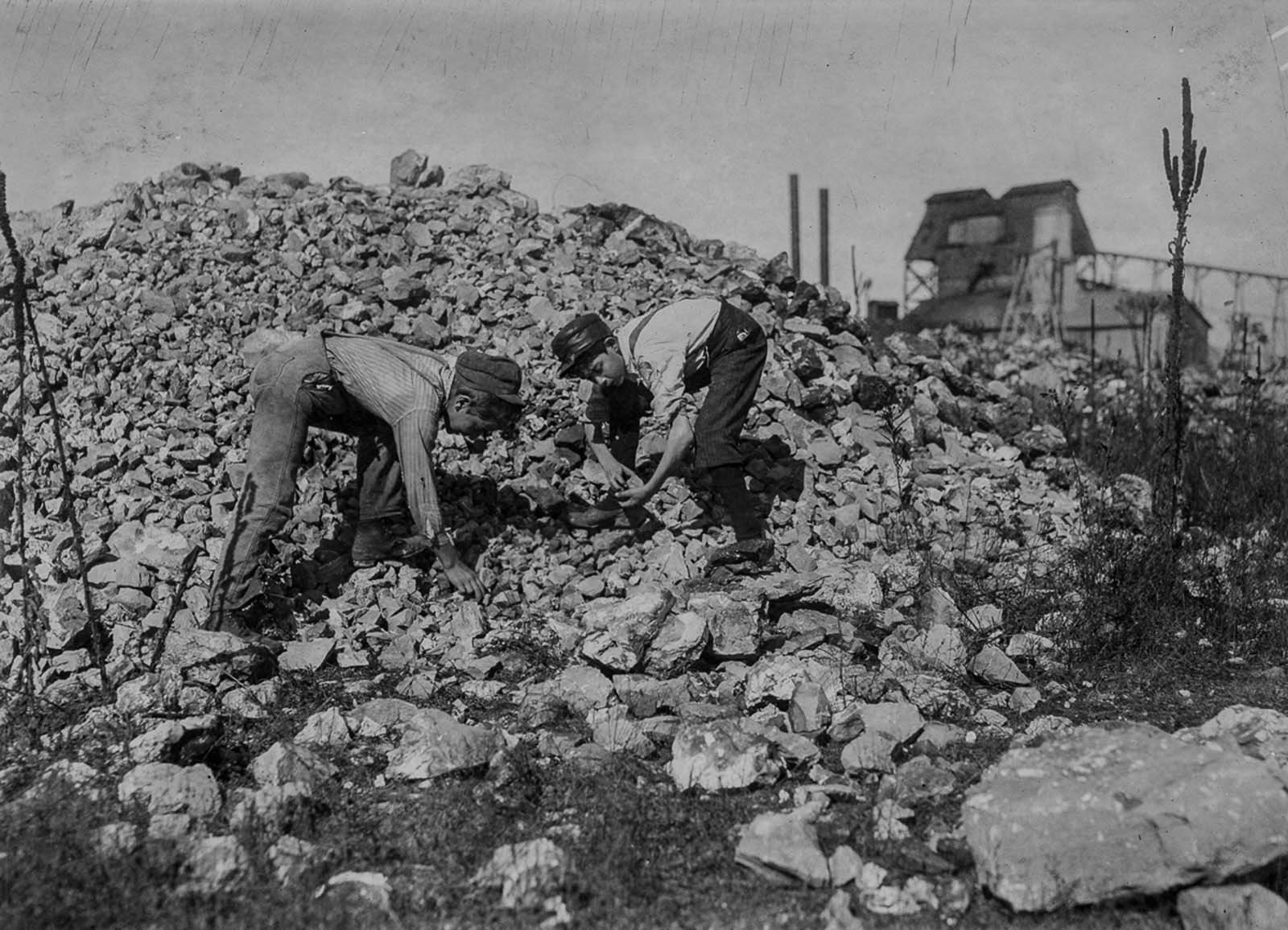 Basil Roberts and James Hopper, both 12, cull through waste from a zinc mine in Aurora, Missouri. 1910.