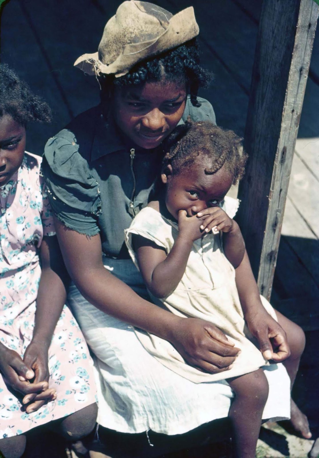 Children sit on the porch of a house at Bayou Bourbeau plantation, a Farm Security Administration cooperative in Louisiana. 1940.