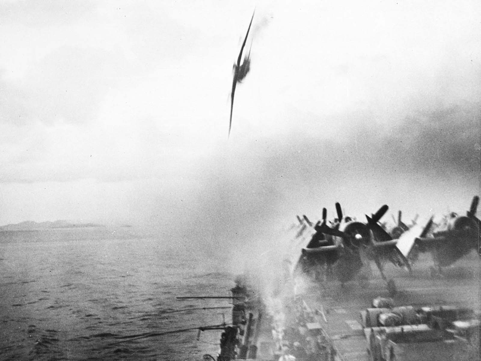 Anti-aircraft gunners, center foreground, pour a deadly stream of fire into an already-burning Japanese Kamikaze plane plummeting toward the flight deck of the USS Sangamon, a Navy escort carrier, during action in the Ryukyu Islands near Japan, on May 4, 1945. This suicide plane landed in the sea close to the carrier. Another Japanese aircraft later succeeded in hitting the ship deck, inflicting heavy damage.