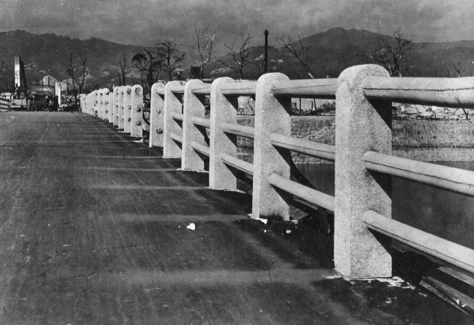 The searing heat from the nuclear explosion above Hiroshima scorched the roadway of this bridge across the Ota River, about a half a mile from the focal point of the bomb burst. The areas shielded by the concrete pillars and railings were left undamaged, creating permanent