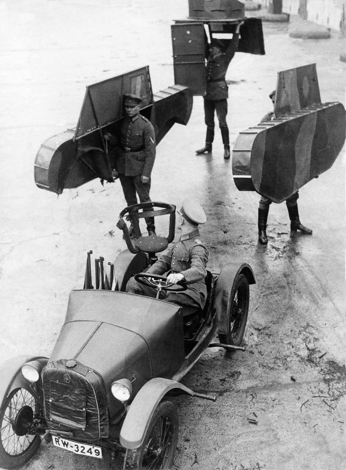 German soldiers carry the shell of a dummy tank to be attached to a car. 1931.