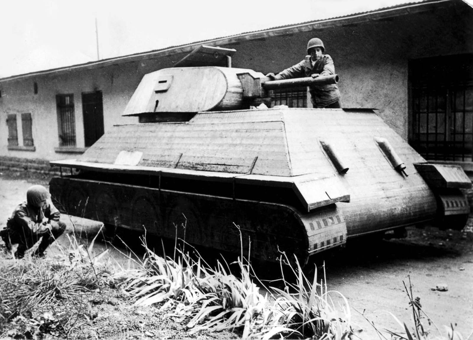 American soldiers inspect a wooden German dummy tank built over a four-ton truck in France. 1944.