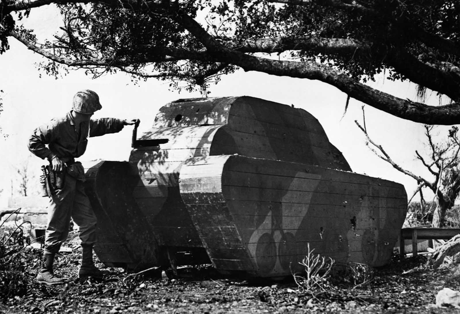 A U.S. Marine rips a wooden slat off a Japanese dummy tank on Okinawa. 1945.