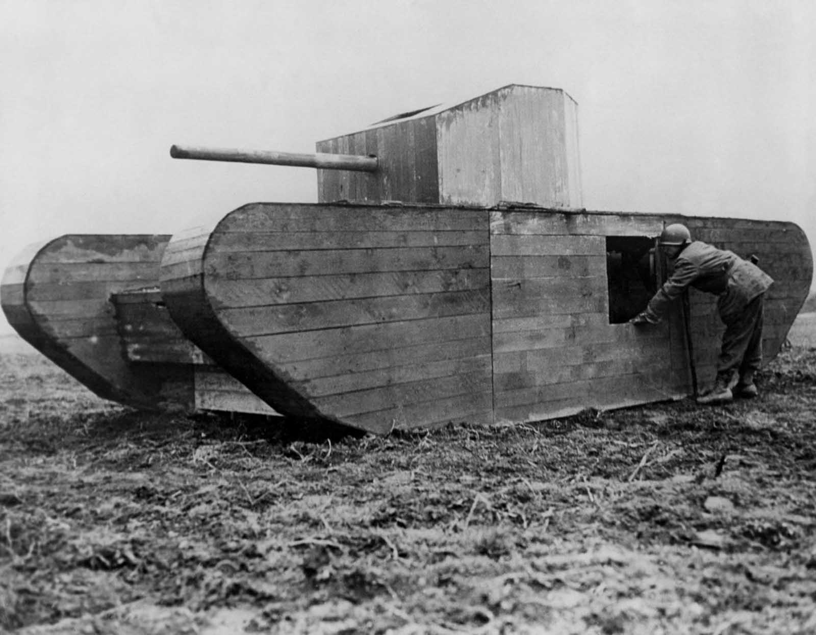 An American soldier peers inside a German dummy tank on the outskirts of Cologne. 1945.