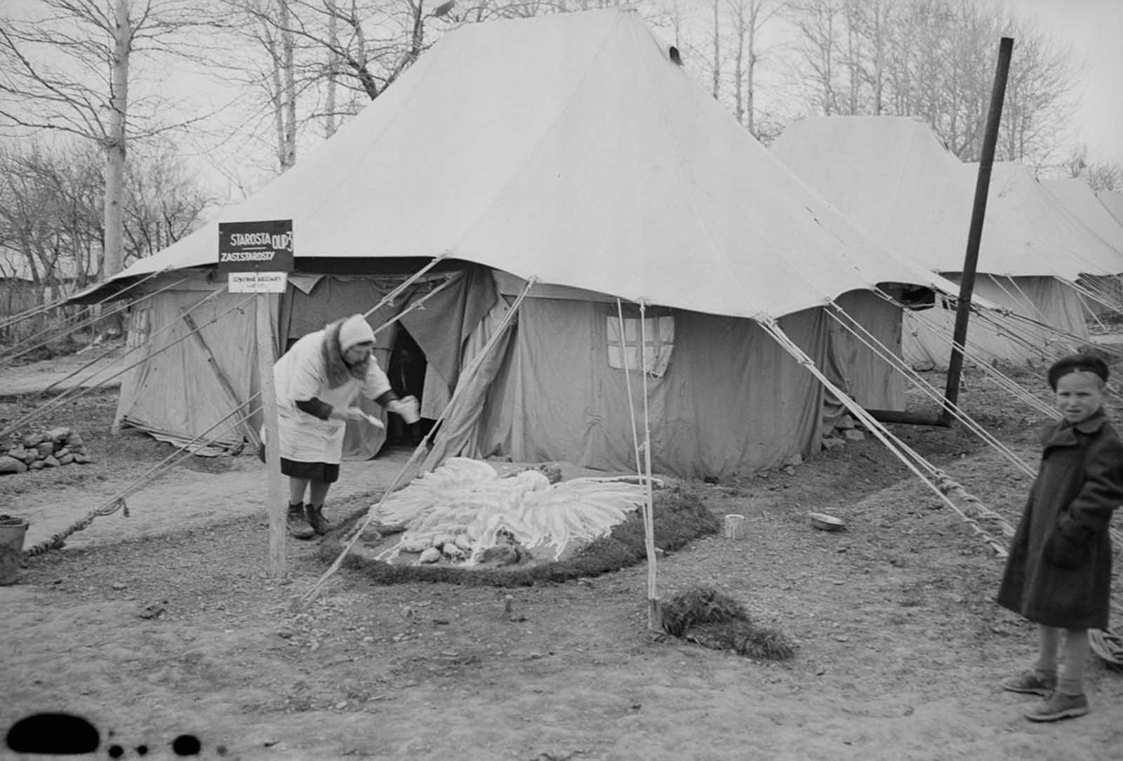 A woman decorates the front yard of her tent with the Polish national eagle.