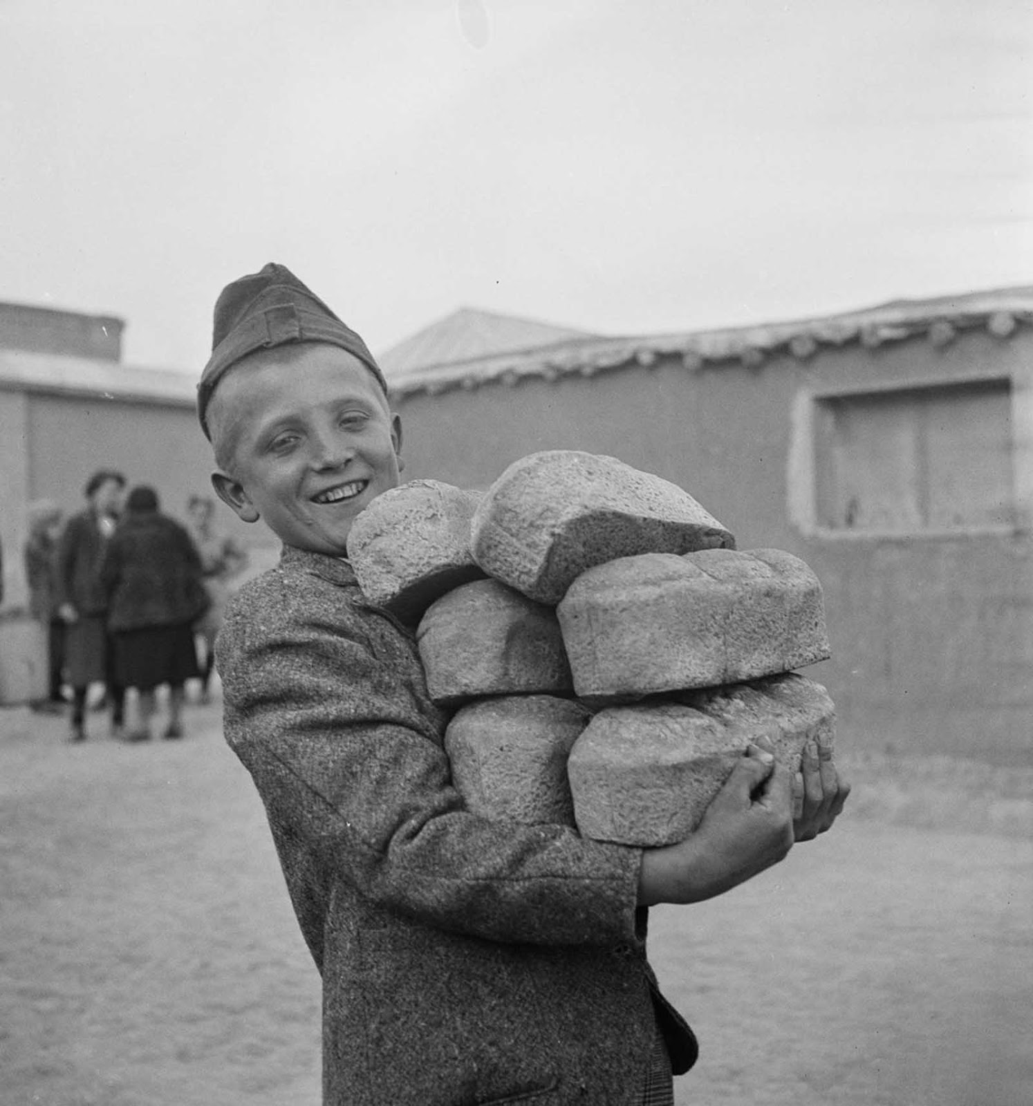 A Polish boy carries loaves of bread provided by the Red Cross.