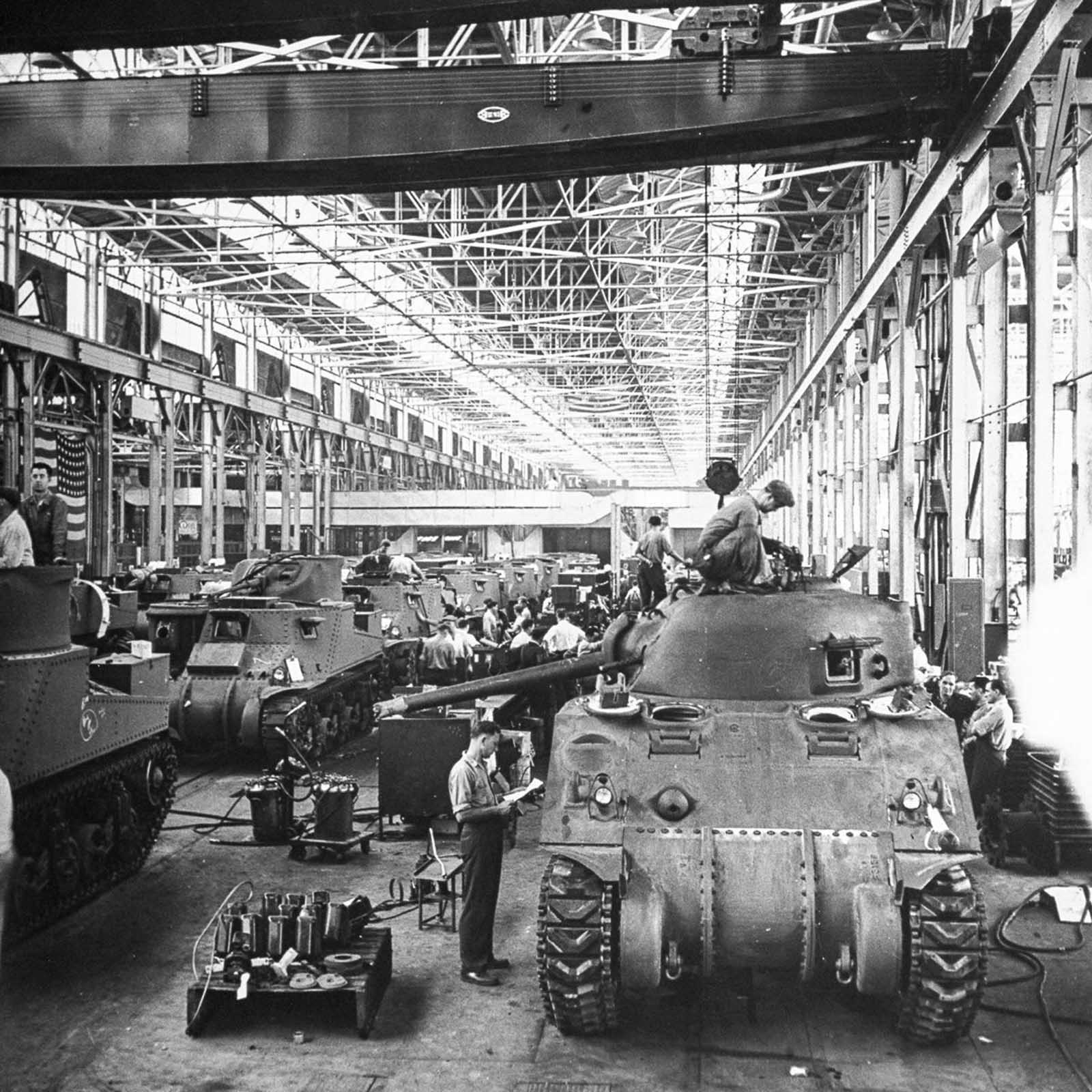 The assembly line at the Chrysler tank arsenal in Michigan changes over from M3 to M4 models while the line continues moving. 1942.