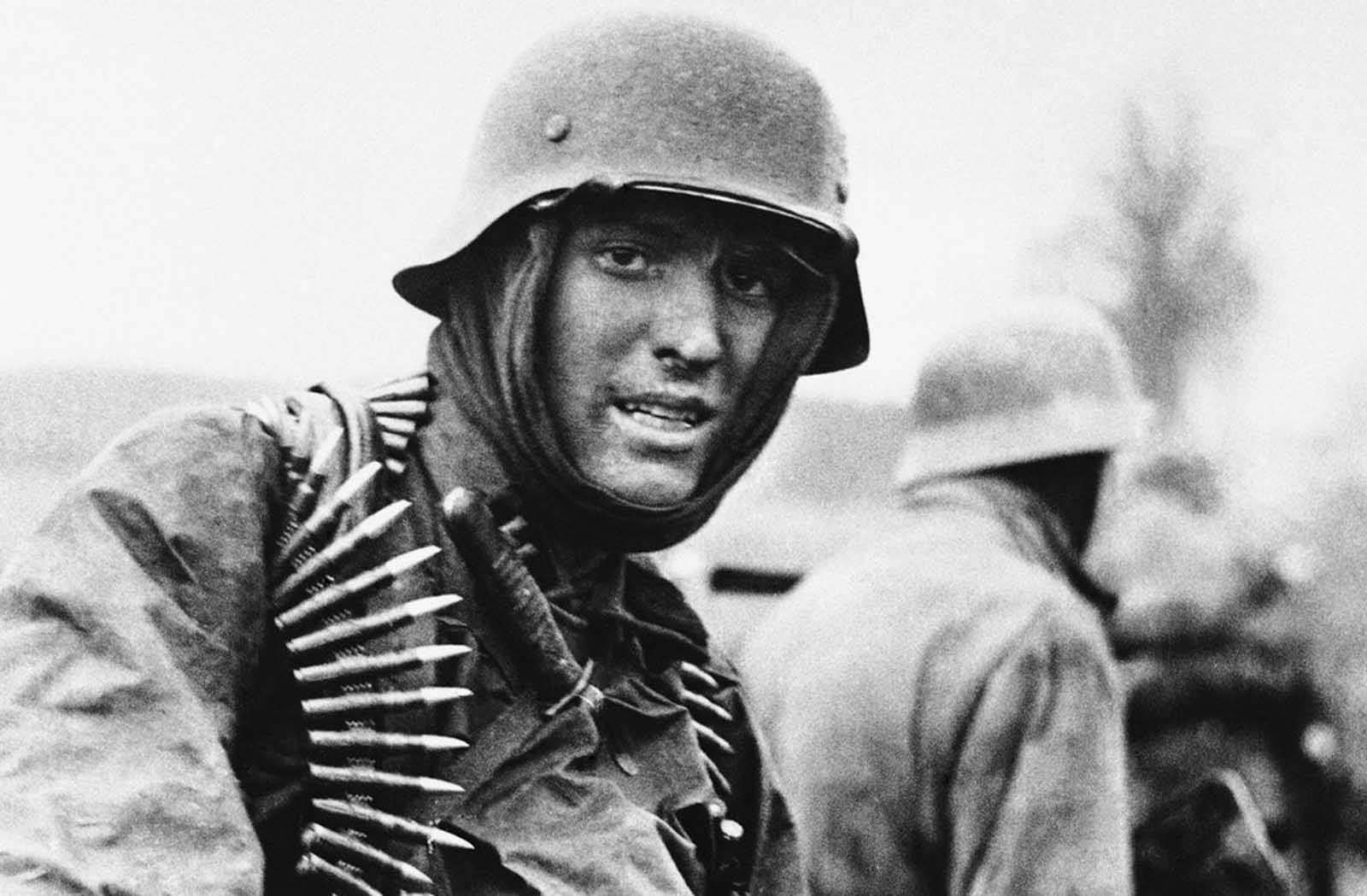 A heavily armed German soldier carries ammunition boxes forward during the German counter-offensive in the Belgium-Luxembourg salient, on January 2, 1945.