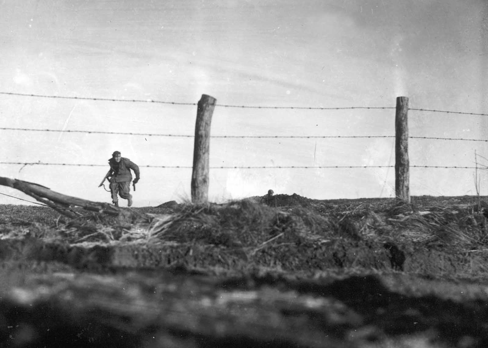 An infantryman from the U.S. Army's 82nd Airborne Division goes out on a one-man sortie while covered by a comrade in the background, near Bra, Belgium, on December 24, 1944.