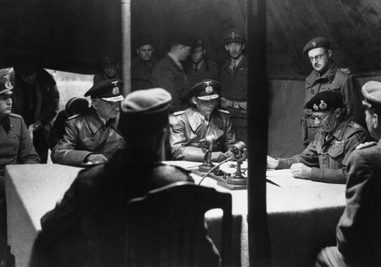 Britain's Field Marshal Bernard Montgomery, right, reads over the surrender pact, while senior German officers, from left, Major Friedel, Rear Admiral Wagner and Admiral Hans-Georg Von Friedeburg, look on, in a tent at Montgomery's 21st Army Group headquarters, at Luneburg Heath, on May 4, 1945. The pact agreed a ceasefire on the British fronts in north west Germany, Denmark and Holland as from 8am on May 5. German forces in Italy had surrendered earlier, on April 29, and the remainder of the the Army in Western Europe surrendered on May 7 -- on the Eastern Front, the German surrender to the Soviets took place on May 8, 1945. More than five years of horrific warfare on European soil was officially over. 