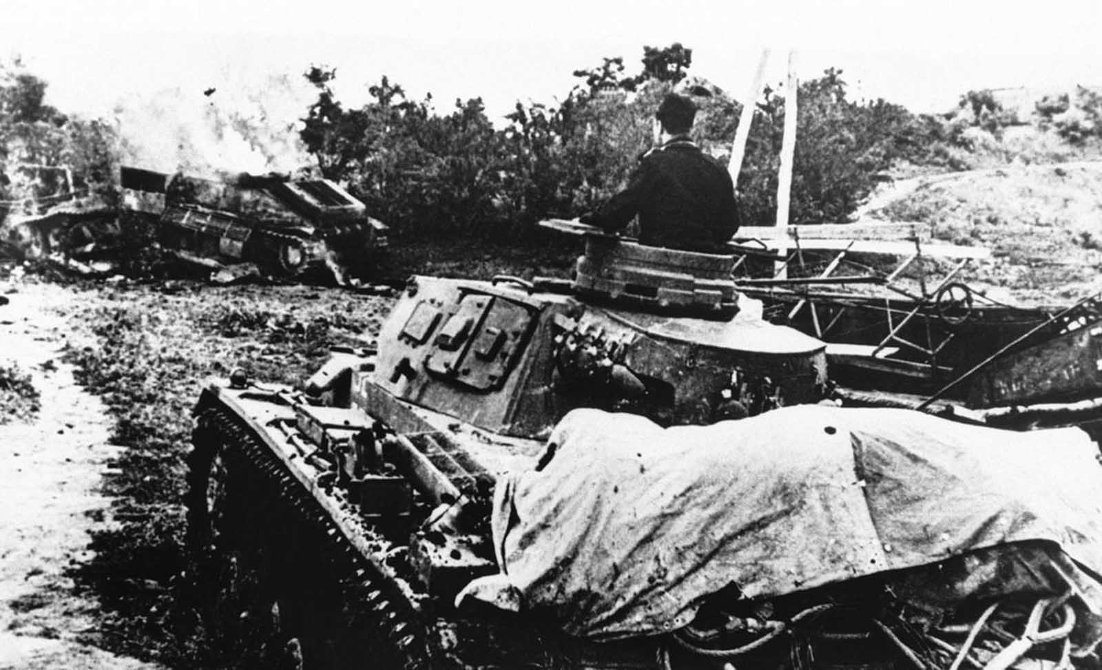 A German tank rolls up to its defeated enemy tank which burns near the edge of a patch of woods, somewhere in Russia, on October 20, 1942.