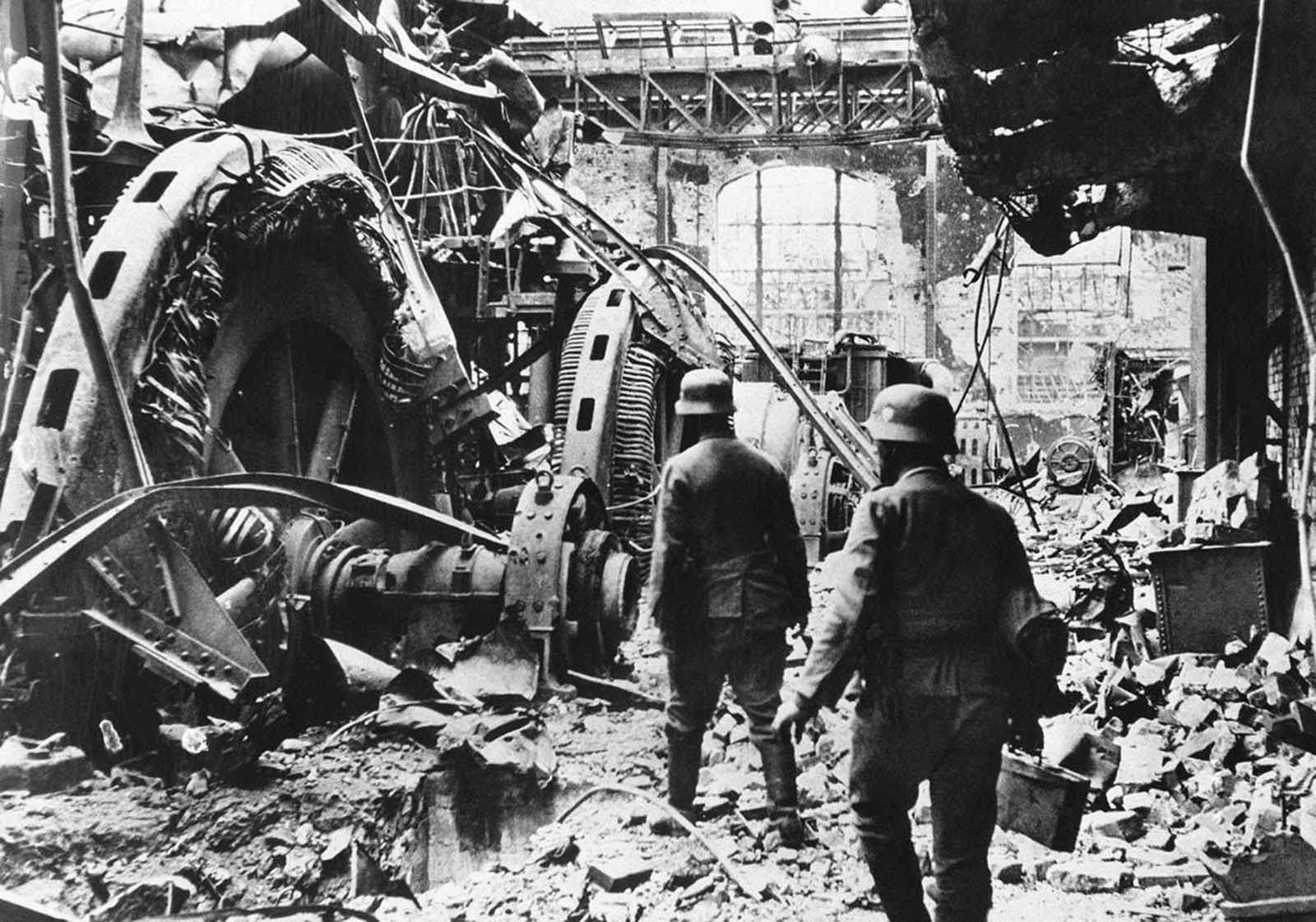 German troops pass through a wrecked generating station in the factory district of Stalingrad, on December 28, 1942.
