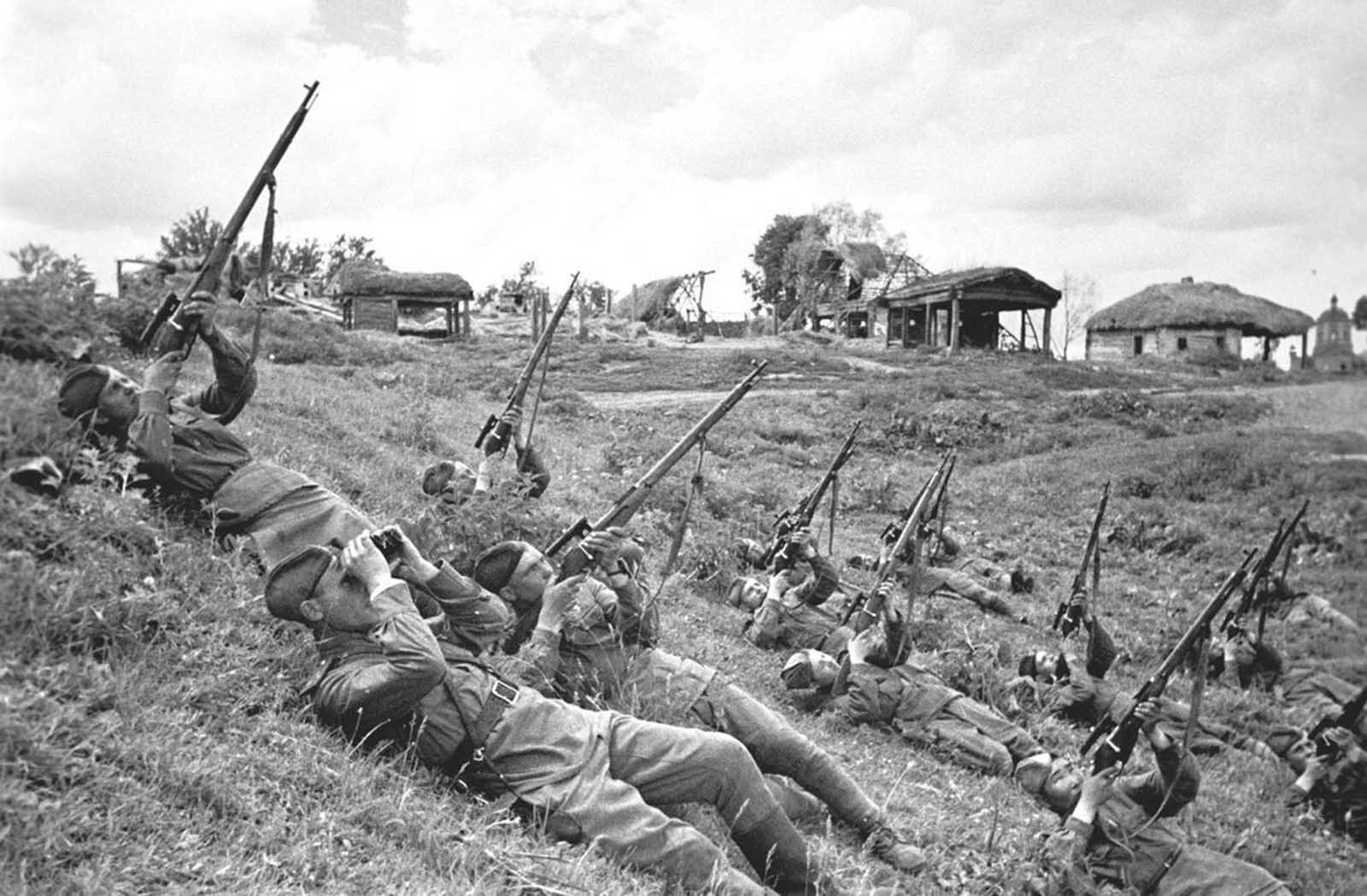 Soviet soldiers, on their backs, launch a volley of bullets at enemy aircraft in June of 1943.