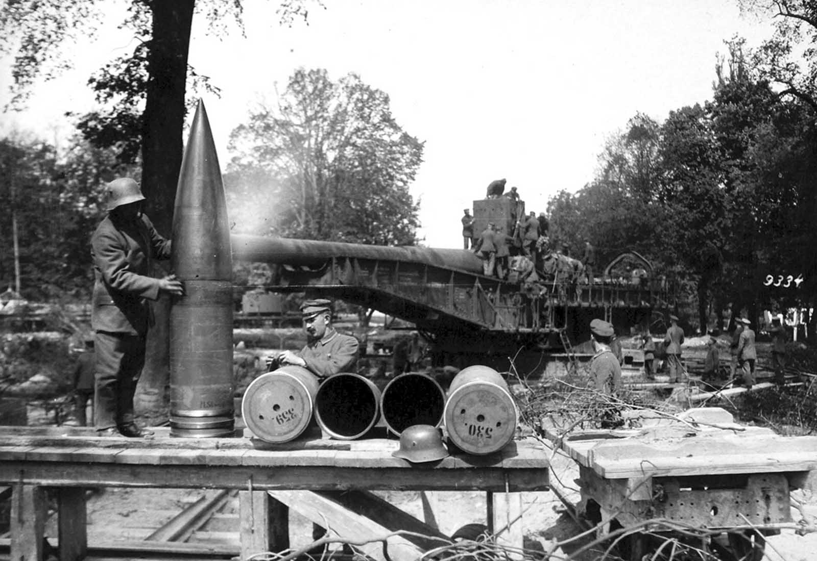 A German soldier rubs down massive shells for the 38 cm SK L/45, or
