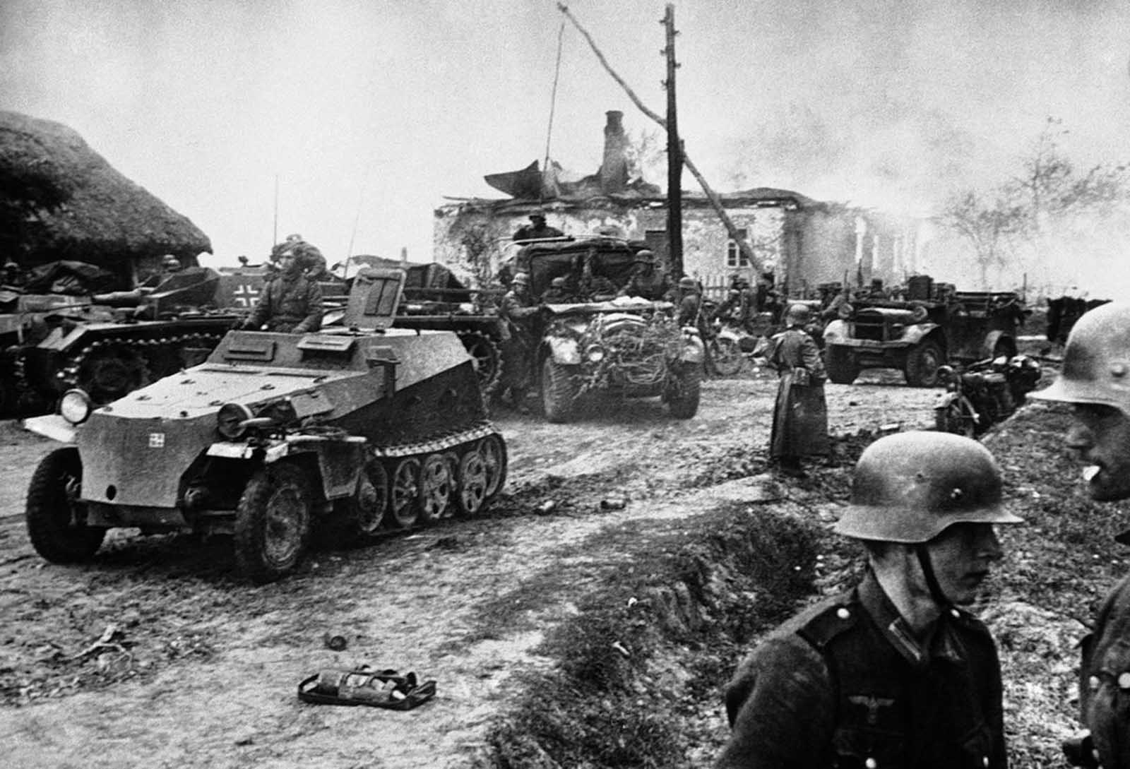 German mechanized troops rest at Stariza, Russia on November 21, 1941, only just evacuated by the Russians, before continuing the fight for Kiev. The gutted buildings in the background testify to the thoroughness of the Russians