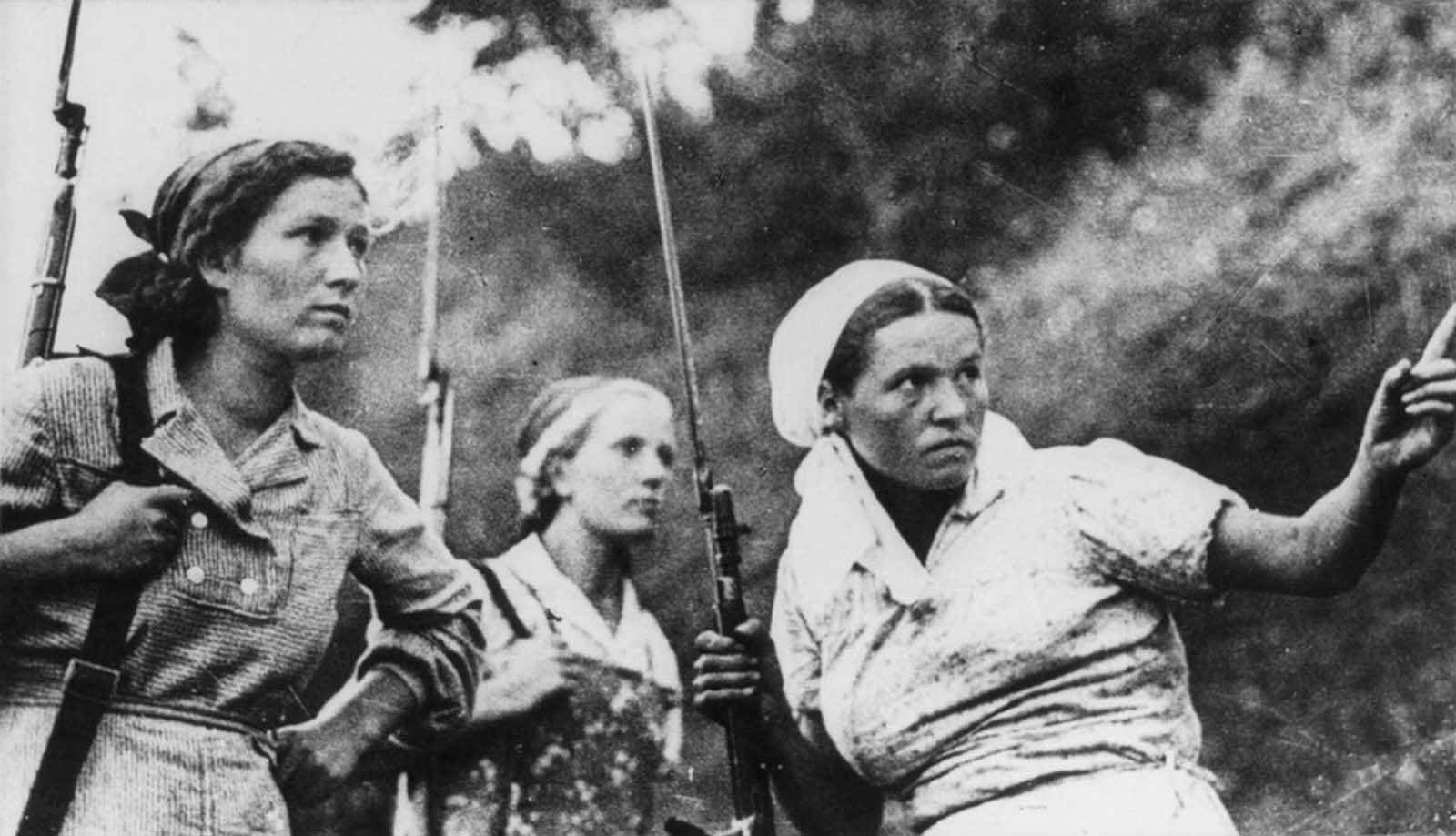 Three Soviet guerrillas in action in Russia during World War II.