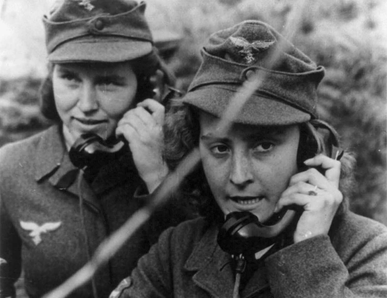 Two women of the German anti-aircraft gun auxiliary operating field telephones during World War II.