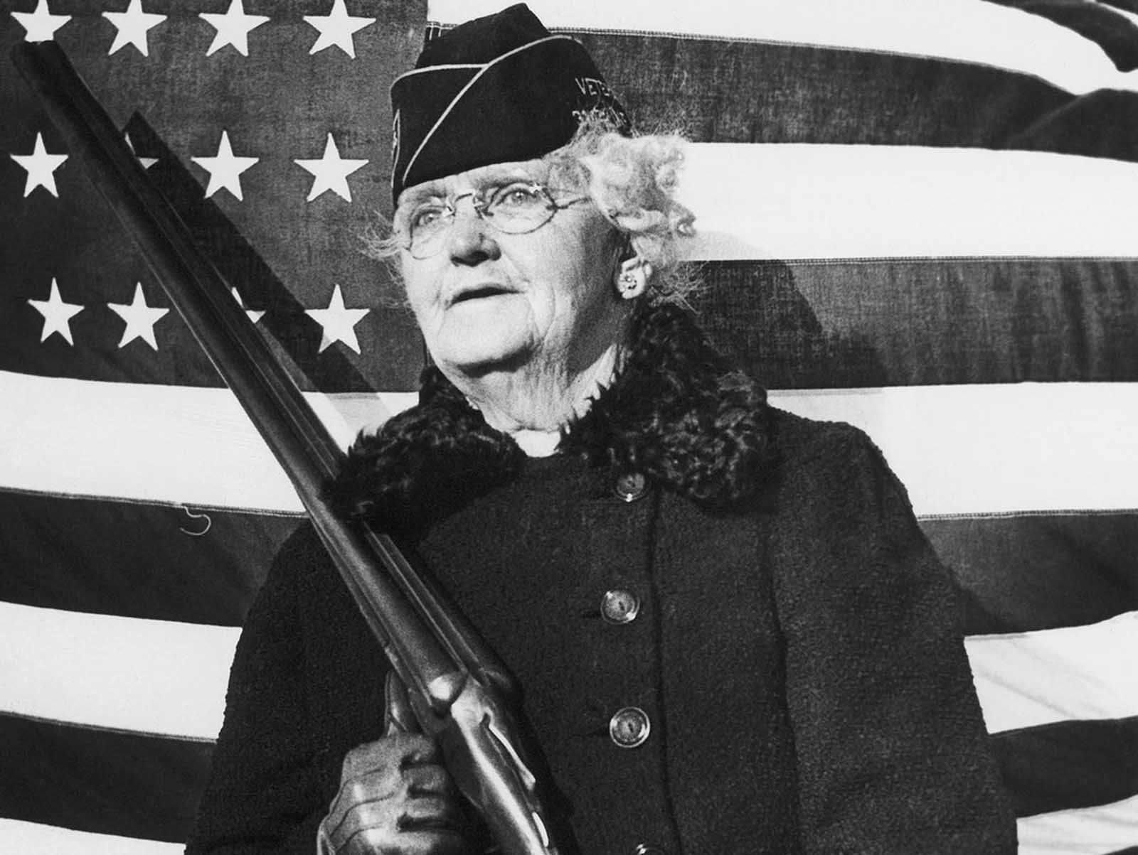 Mrs. Paul Titus, 77-year-old air raid spotter of Bucks County, Pennsylvania, carries a gun as she patrols her beat, on December 20, 1941. Mrs. Titus signed-up the day after the Pearl Harbor attack.