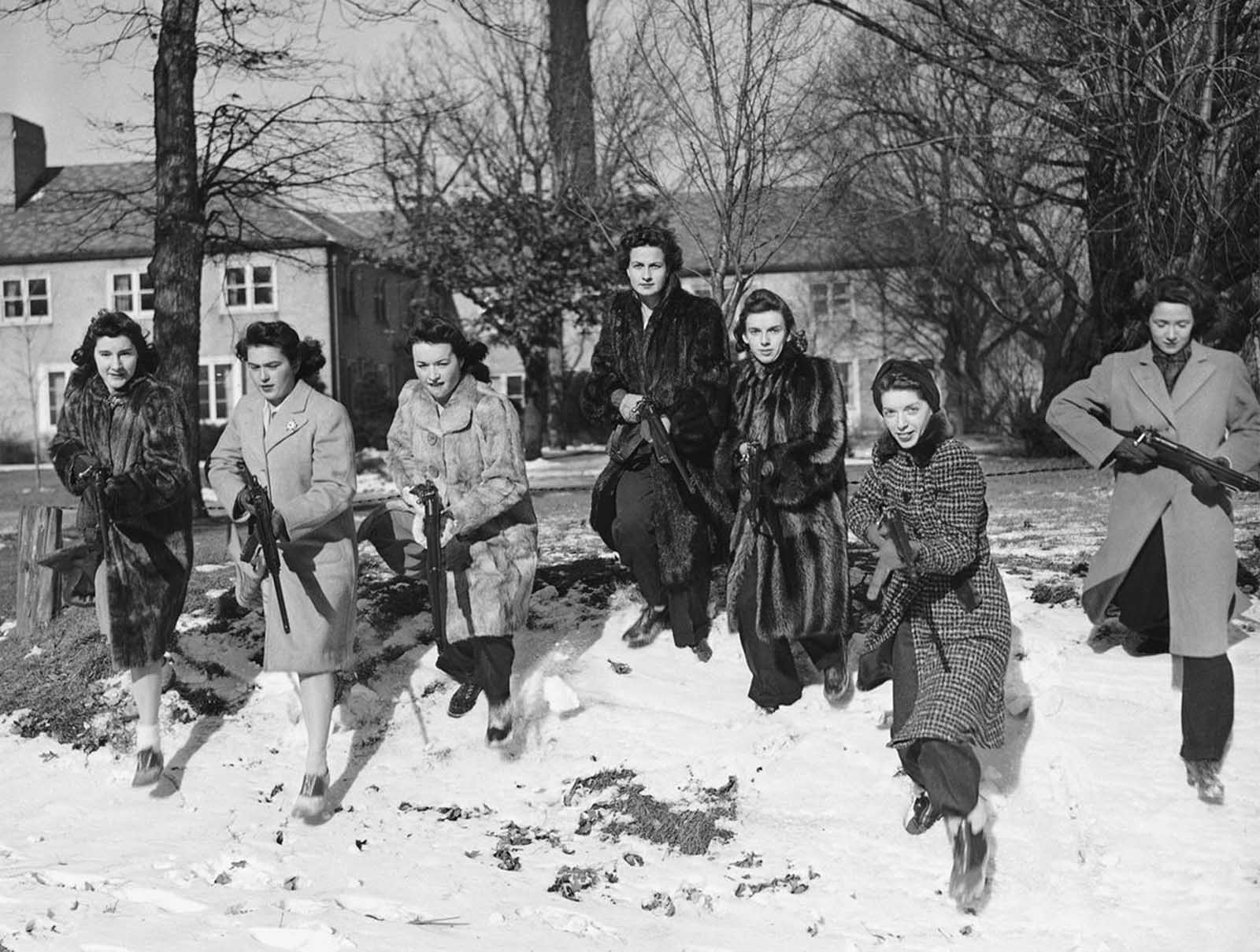 These Northwestern University girls brave freezing weather to go through a Home Guard rifle drill on the campus in Evanston, Illinois on January 11, 1942. From left to right are: Jeanne Paul, age 18, of Oak Park, Illinois,; Virginia Paisley, 18, of Lakewood, Ohio; Marian Walsh, 19, also from Lakewood; Sarah Robinson, 20, of Jonesboro, Arkansas,; Elizabeth Cooper, 17, of Chicago; Harriet Ginsberg, 17.