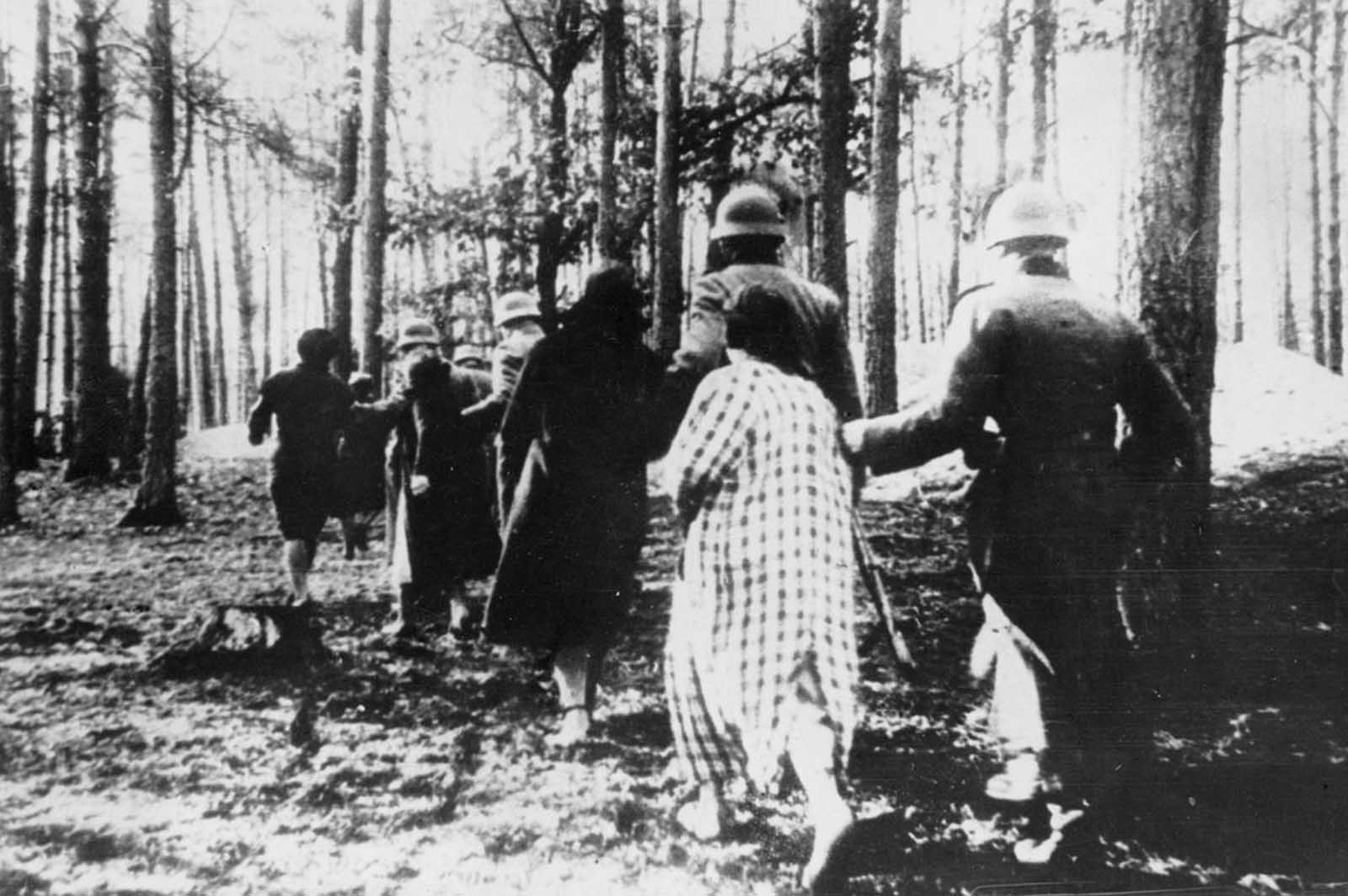 Polish women are led through woods to their executions by German soldiers sometime in 1941.