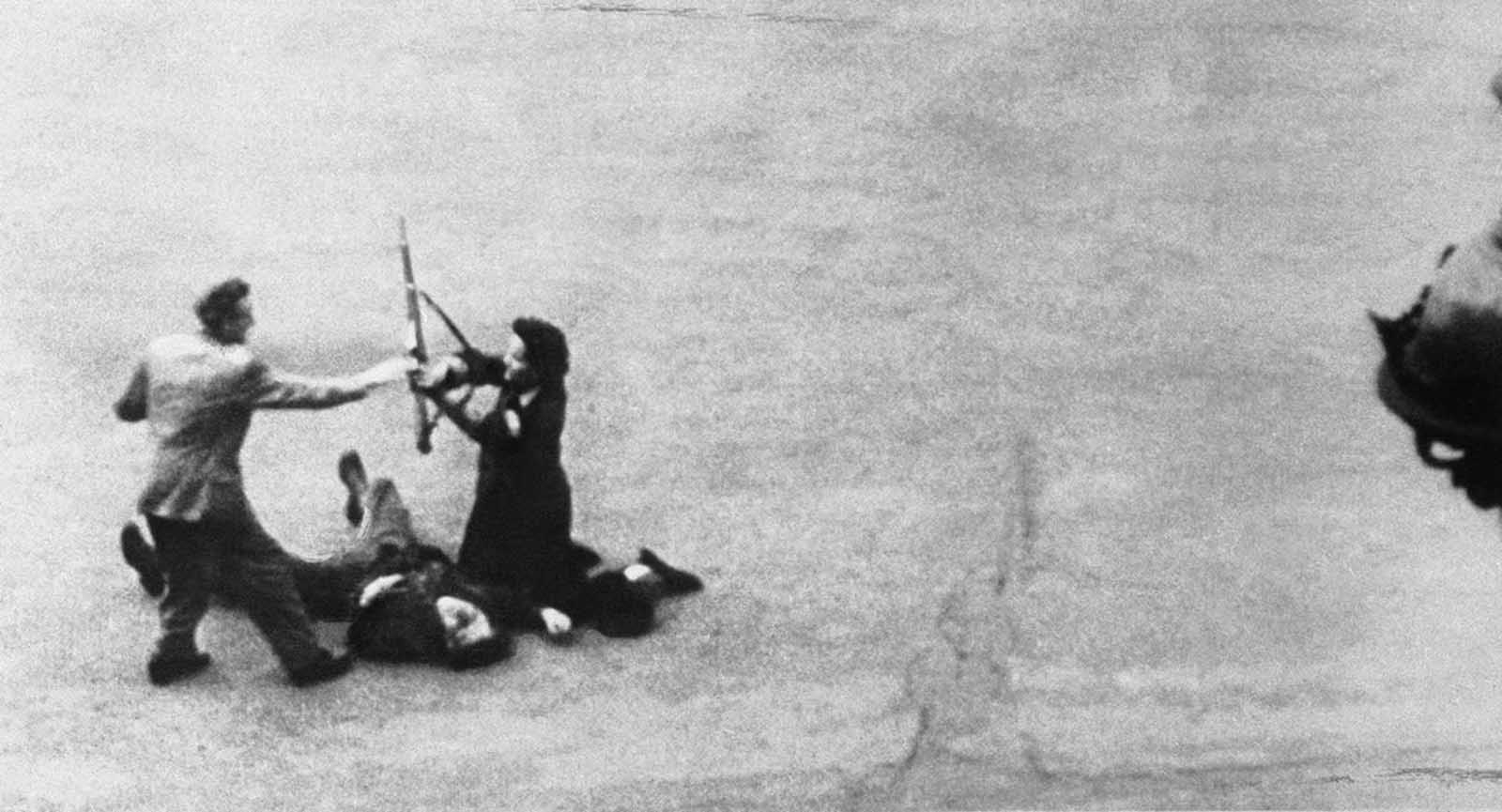 A German soldier, wounded by a French bullet, is disarmed by two members of the French Forces of the interior, one a woman, during street fighting that preceded the entry of allied troops into Paris in 1944.