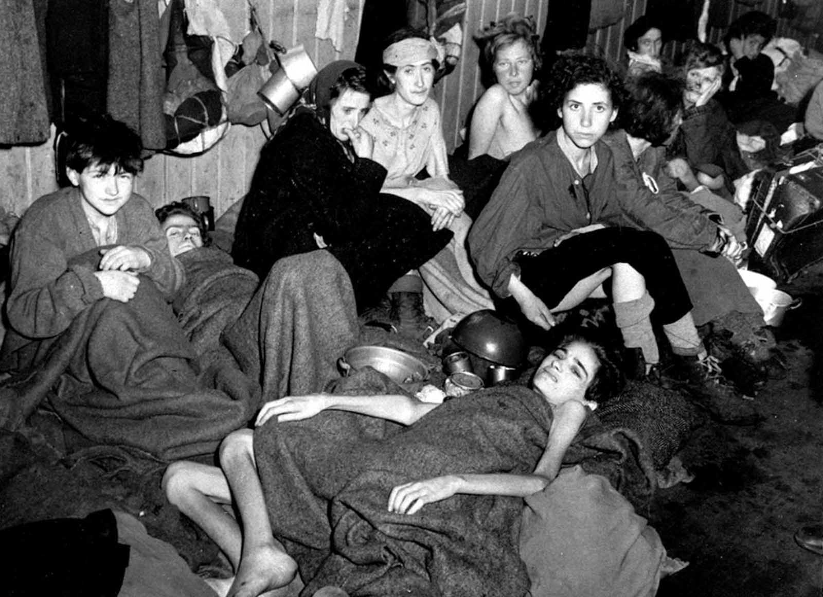 Women and children, some of over 40,000 concentration camp inmates liberated by the British, suffering from typhus, starvation and dysentery, huddle together in a barrack at Bergen-Belsen, Germany, in April 1945.