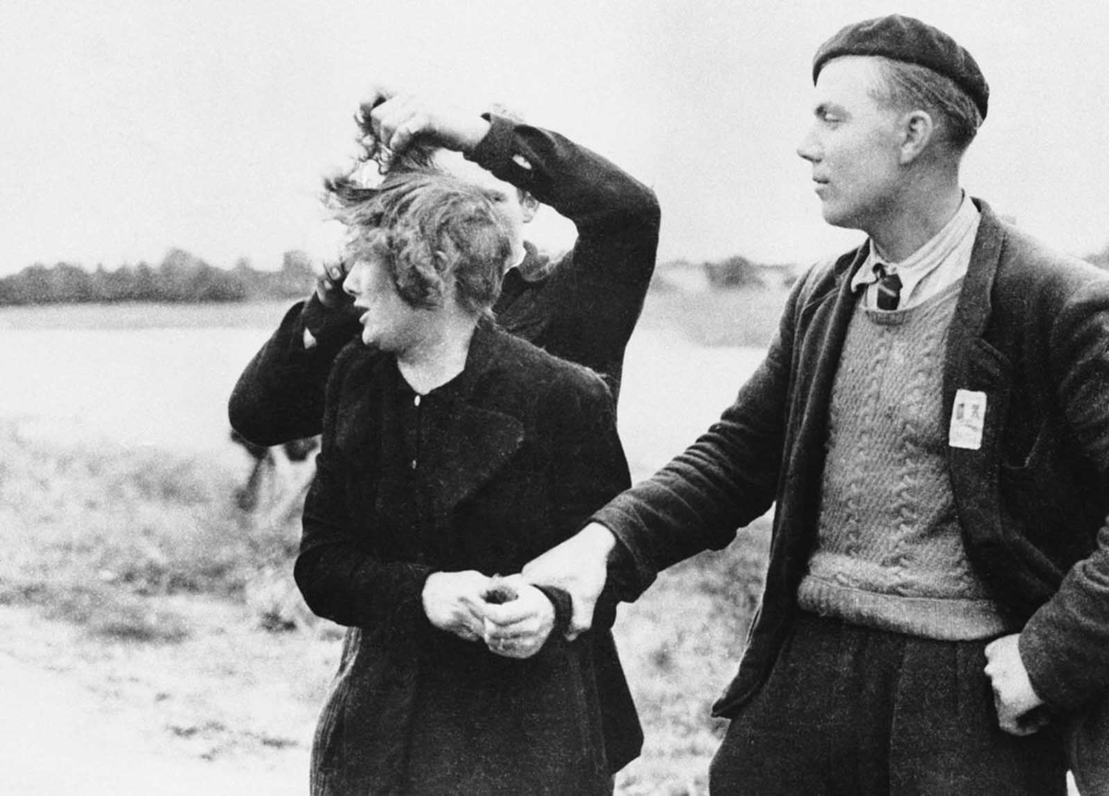 Grande Guillotte of Normandy, France, pays the price for being a collaborationist by having her hair sheared by avenging French patriots on July 10, 1944. Man at right looks on with grim satisfaction at the unhappy girl.