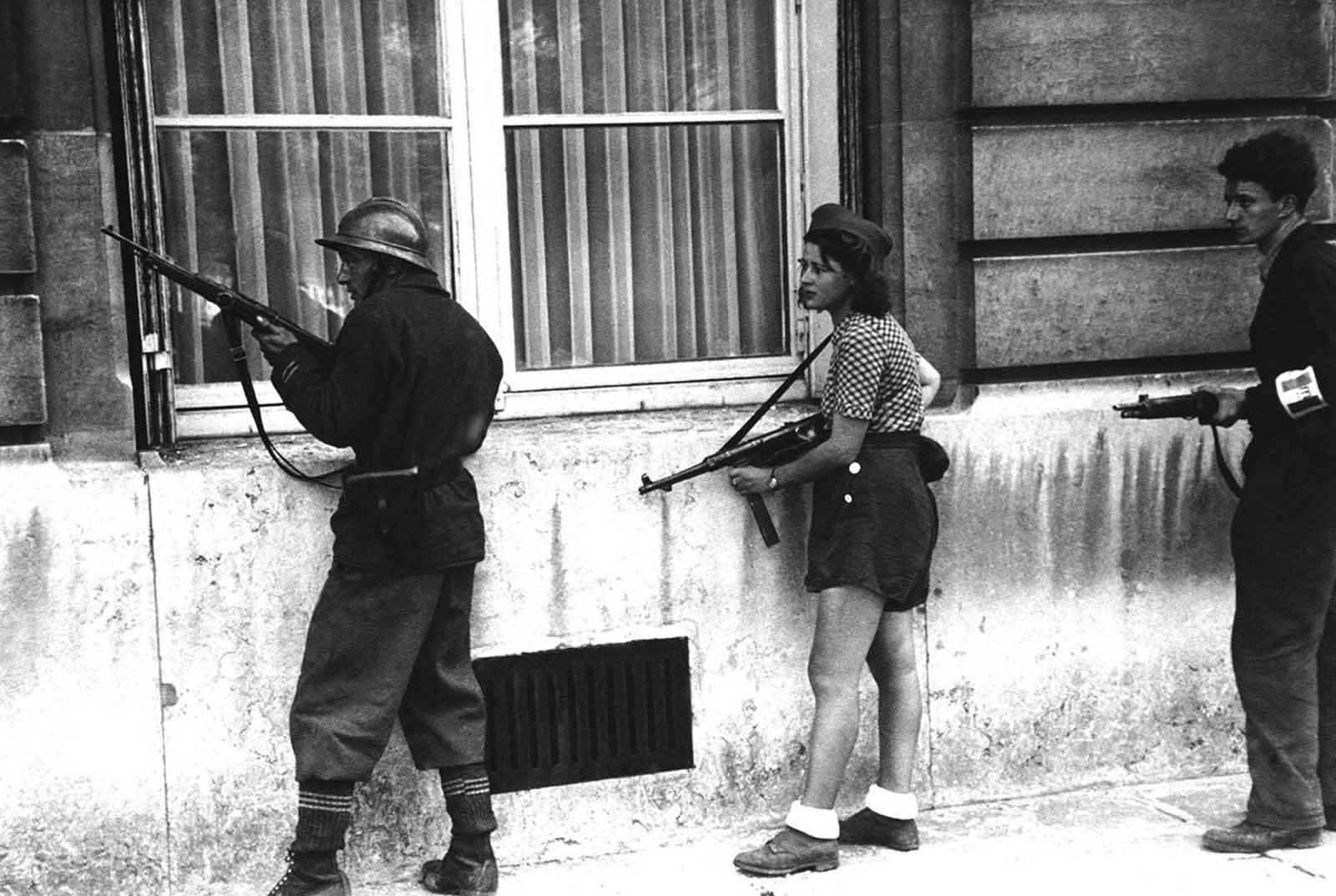A girl of the resistance movement is a member of a patrol to rout out the Germans snipers still left in areas in Paris, France, on August 29, 1944. The girl had killed two Germans in the Paris Fighting two days previously.