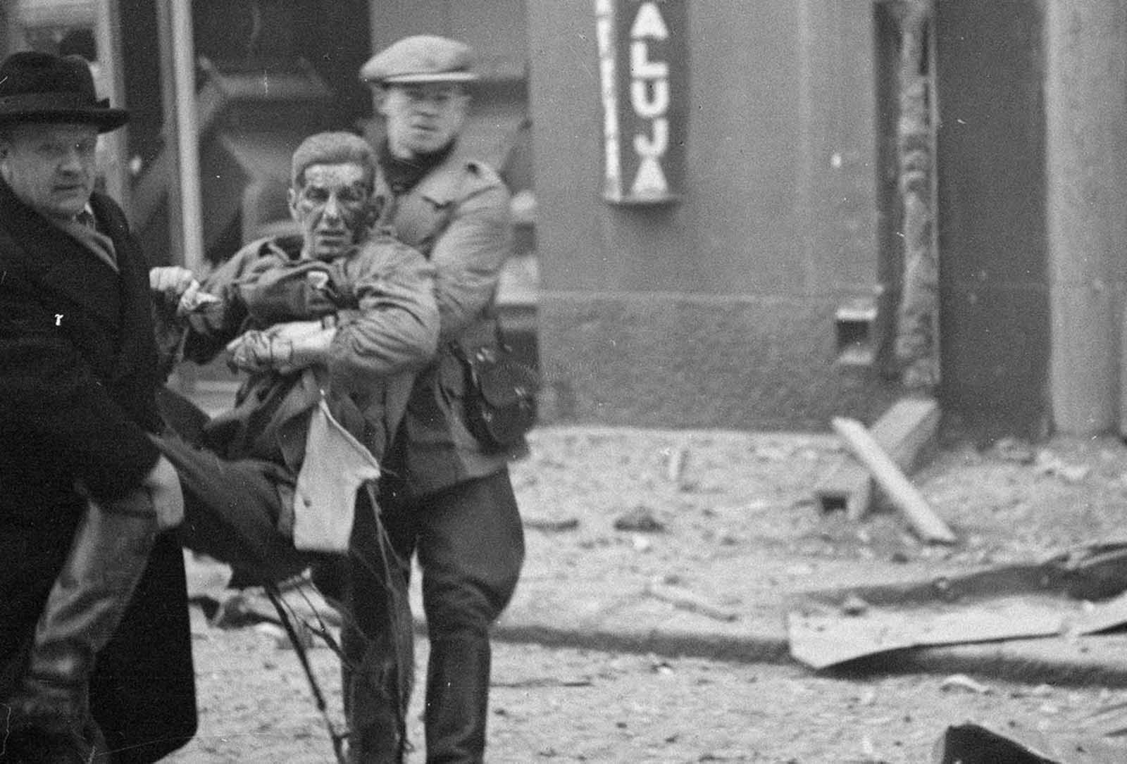 A wounded man is carried away after bombardment of a civilian area.