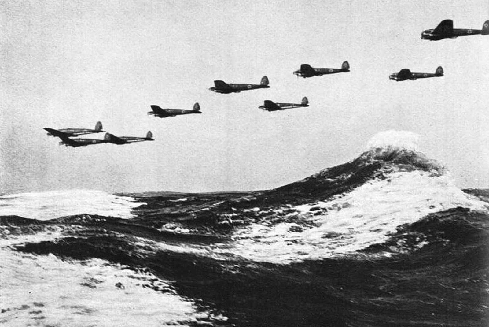 A formation of low-flying German Heinkel He 111 bombers flies over the waves of the English Channel in 1940.