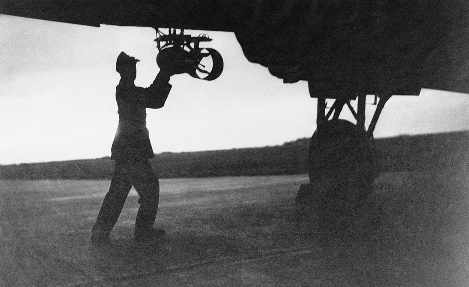 A bomb is fitted to the wings of a British raider prior to the start of an assault on Berlin, on October 24, 1940.