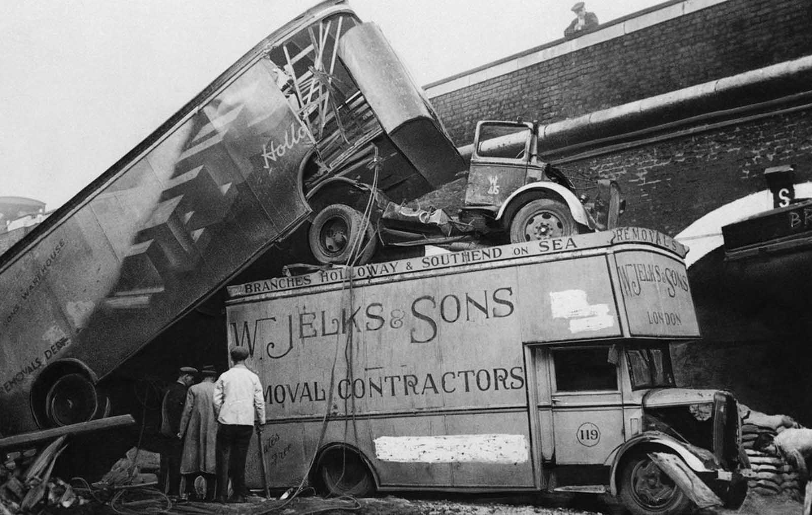 The force of a bomb blast in London piled these furniture vans atop one another in a street after a raid on December 5, 1940.