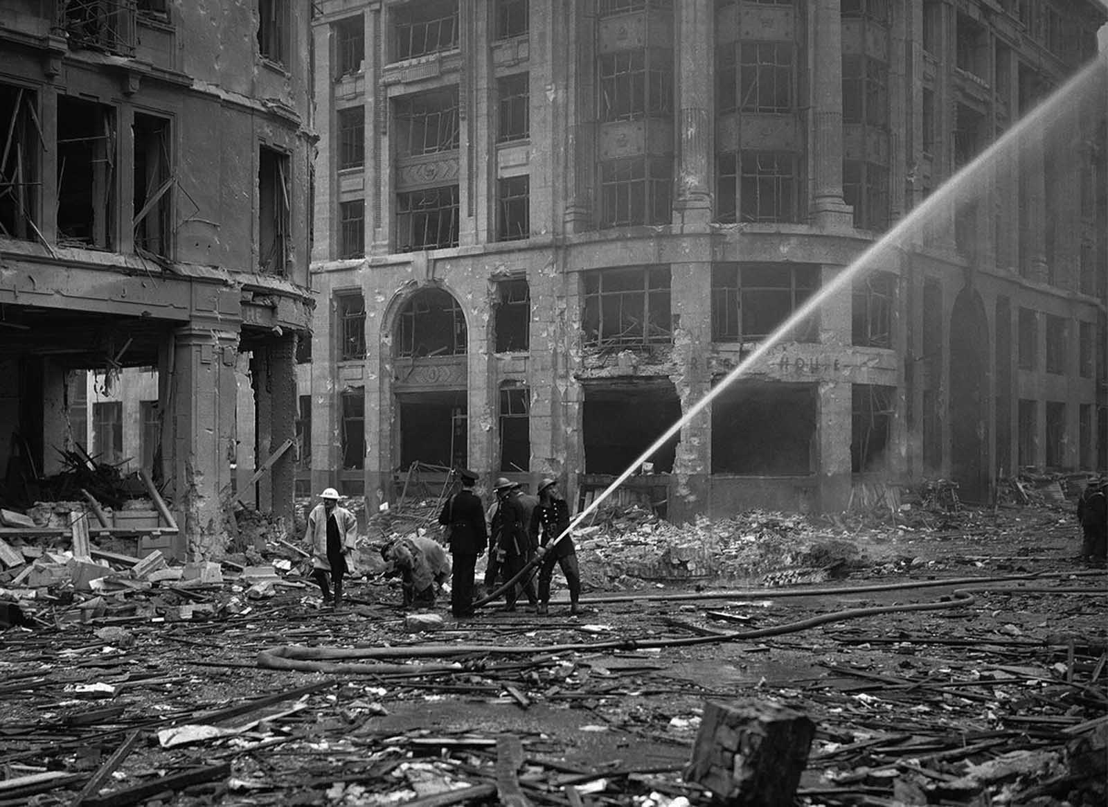 Firemen spray water on damaged buildings, near London Bridge, in the City of London on September 9, 1940, after a recent set of weekend air raids.