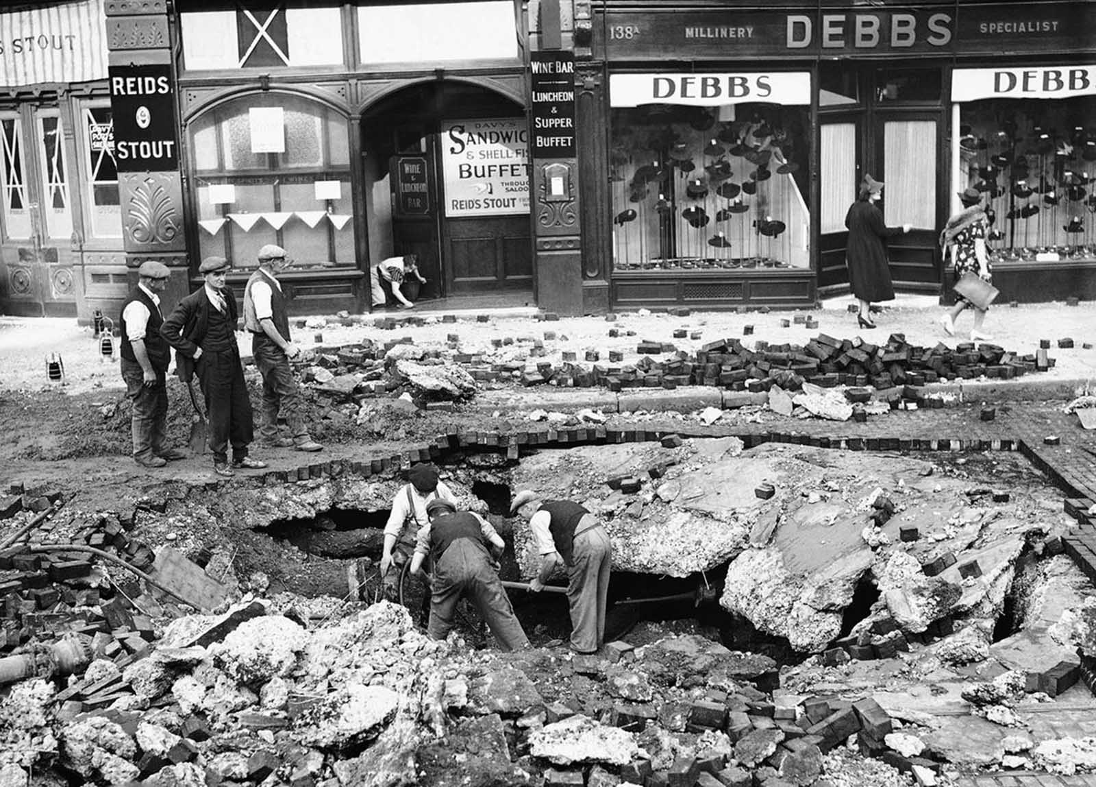 A huge crater was made in a road at Elephant & Castle, London on September 7, 1940, after a night raid on London.