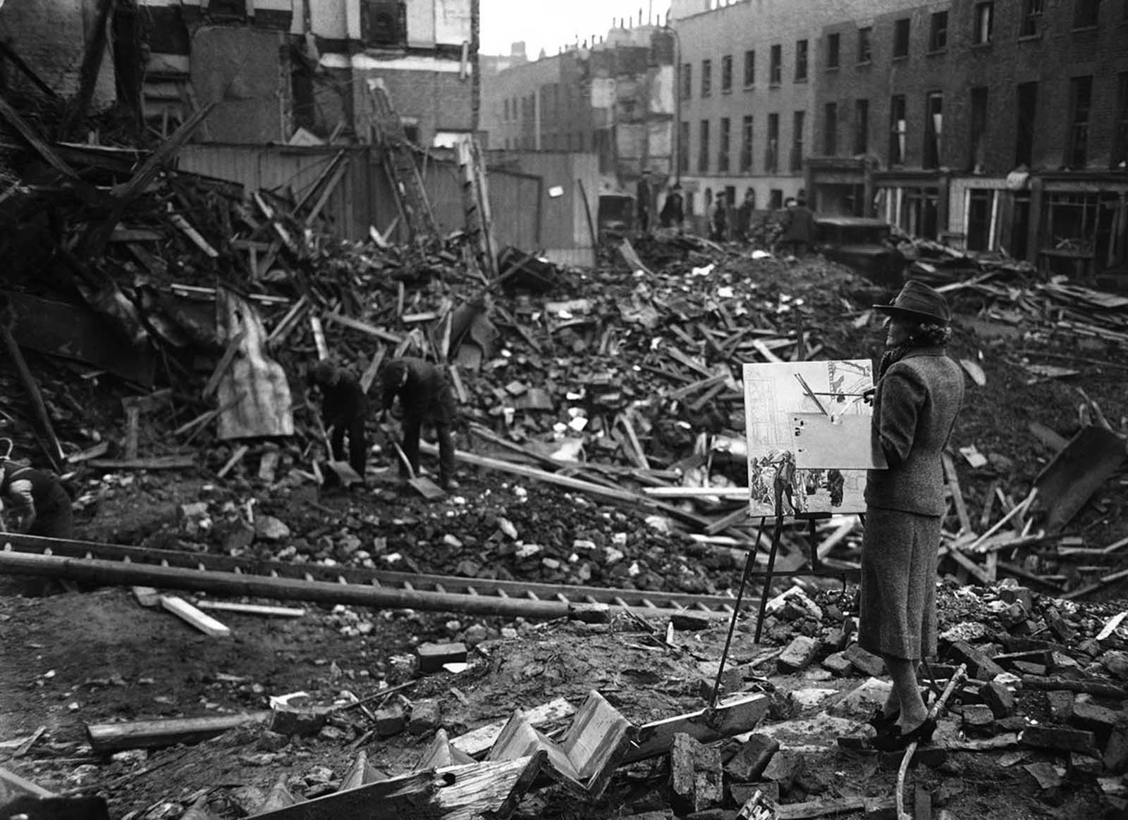 The artist Ethel Gabain, newly appointed by the Ministry of Information to make historical war pictures, at work among bombed ruins in the East End of London on November 28, 1940.