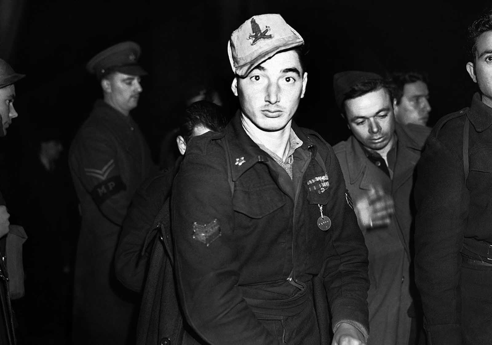 One of the many Italian prisoners of war captured in Libya, who arrived in London on January 2, 1942. This one is still wearing his Africa Corps cap.