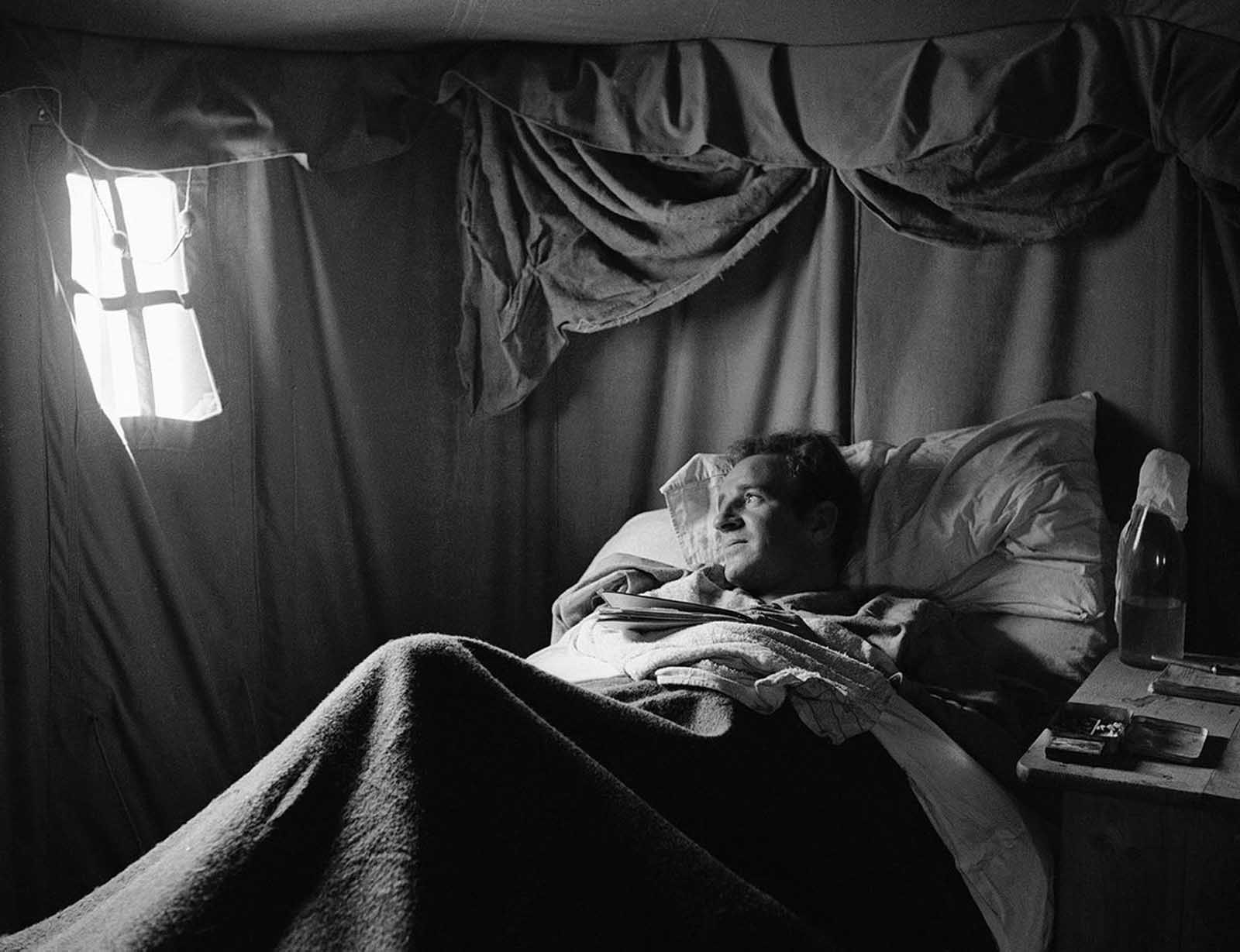 A wounded British warrior in Libya lies on cot in a desert hospital tent, on June 18, 1942, shielded from the strong tropical sun.