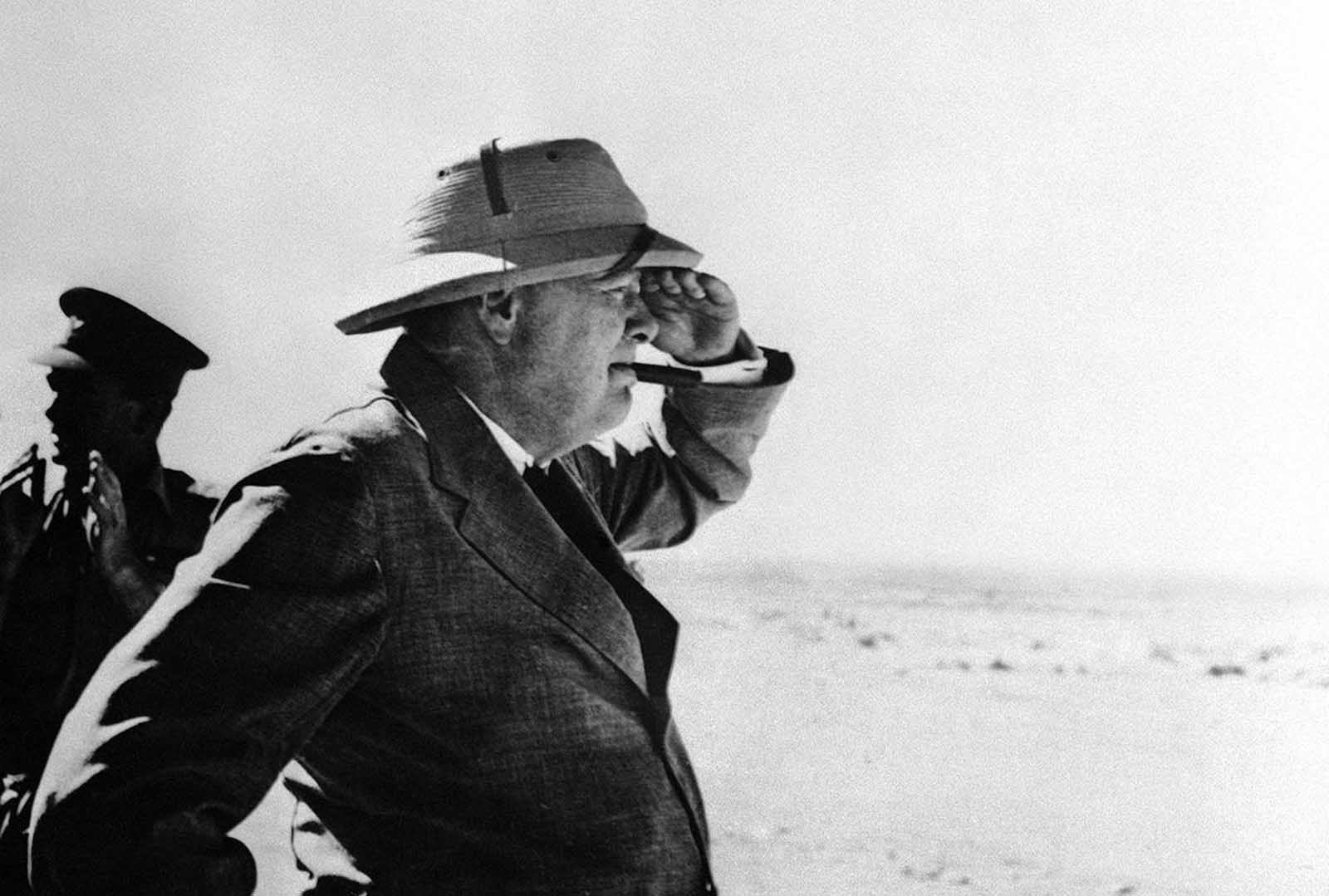 During his stay in the Middle East, Britain's Prime Minister Winston Churchill paid a visit to the Alamein area, meeting brigade and divisional commanders, visiting a gun site, and inspecting personnel of Australian and South African divisions, on August 19, 1942 in the western desert.
