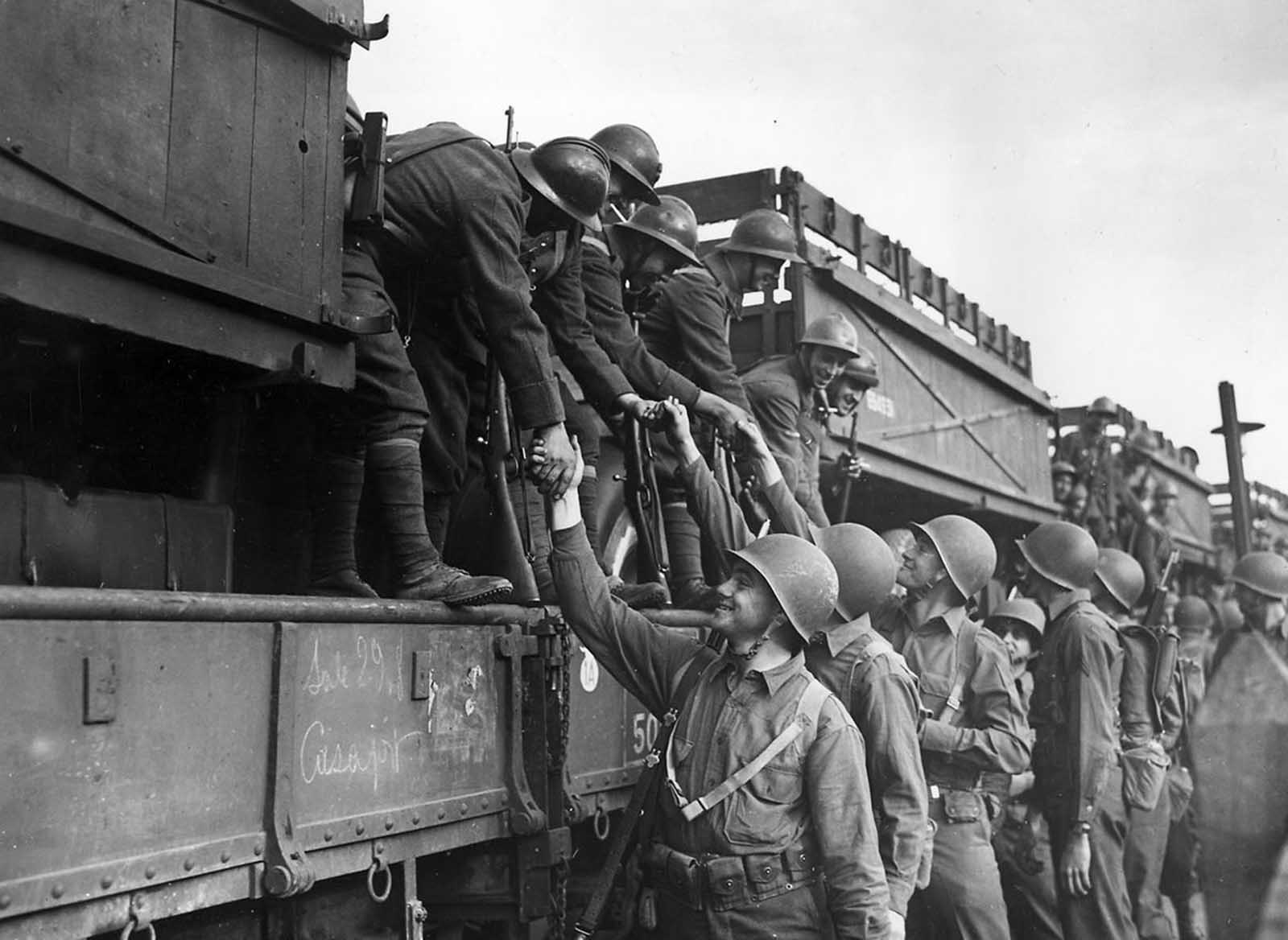 French troops on their way to the fighting lines in Tunisia shake hands with American soldiers at the rail station in Oran, Algeria, North Africa, on December 2, 1942.