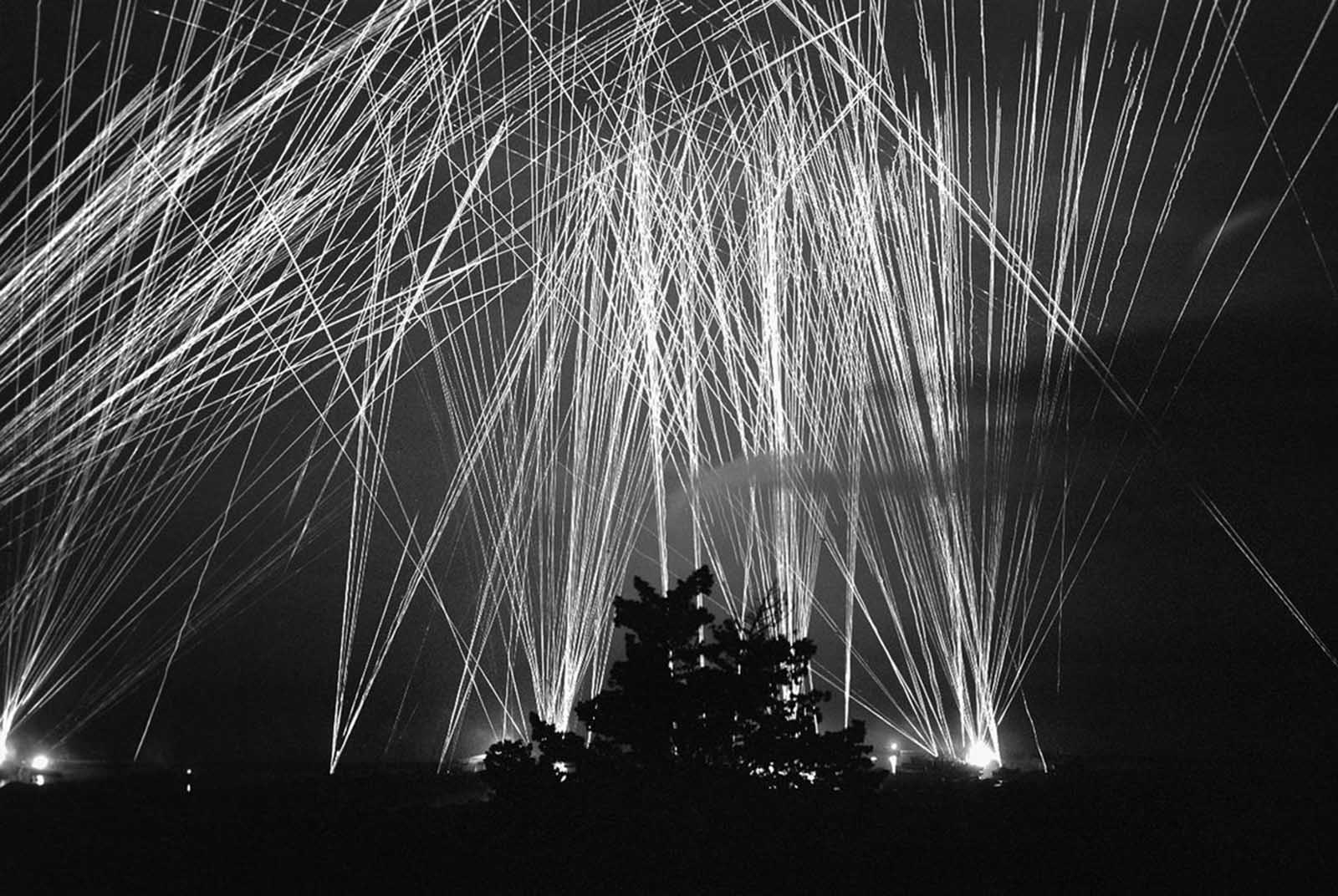 This pattern of anti-aircraft fire provides a protective screen over Algiers at night. The photo, recording several moments of gunfire, shows a defense thrown up during an axis raid upon Algiers in North Africa on April 13, 1943.