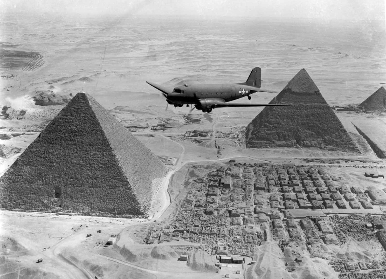After the defeat of Axis forces in Northern Africa, Allied troops prepared to use the territory to launch attacks on Italy and other parts of southern Europe. Here, a U.S. Air Transport Command plane, loaded with war supplies, flies over the pyramids at Giza, near Cairo, Egypt, in 1943.