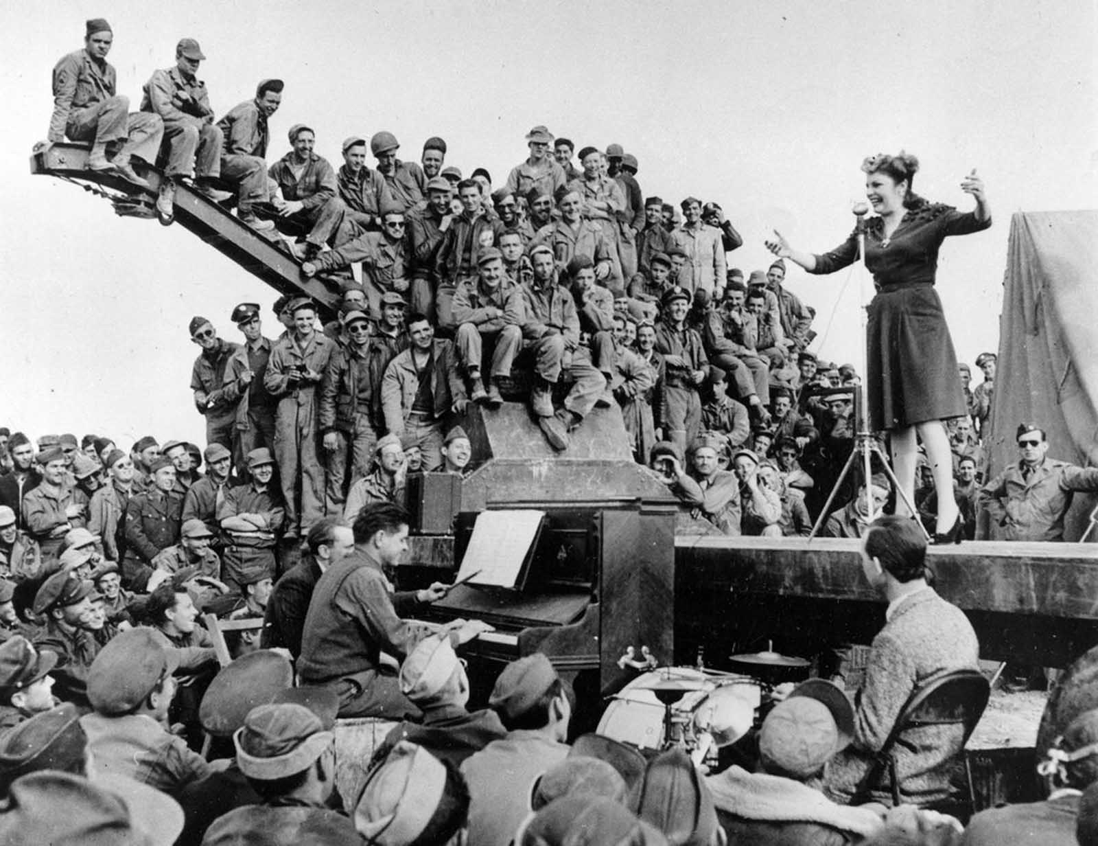 Actress-comedian Martha Raye entertains servicemen of the U.S. Army 12th Air Force on a makeshift stage on the edge of the Sahara Desert in North Africa in 1943.