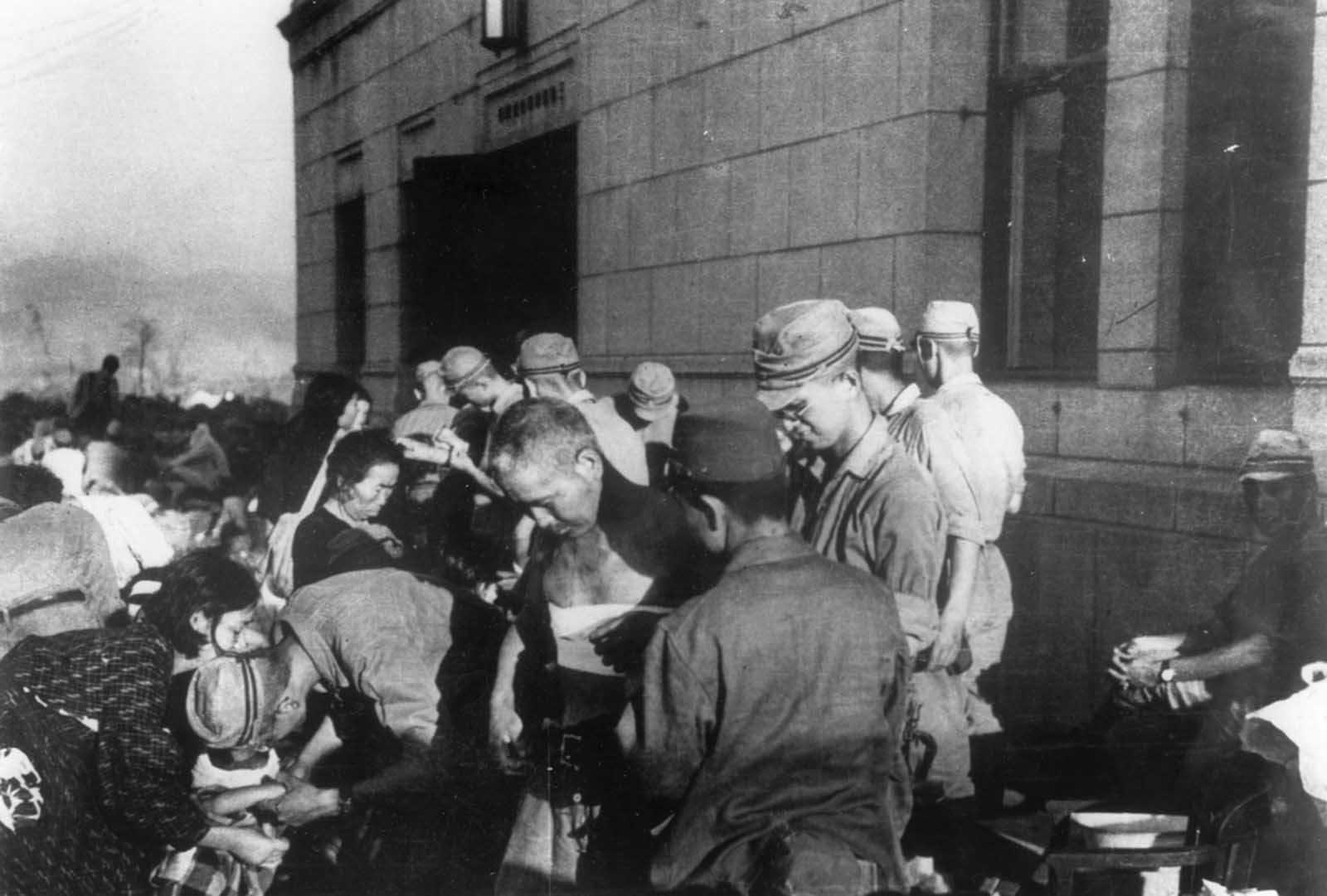 Shortly after the atomic bomb was dropped over the Japanese city of Hiroshima, survivors receive emergency treatment from military medics on August 6, 1945.