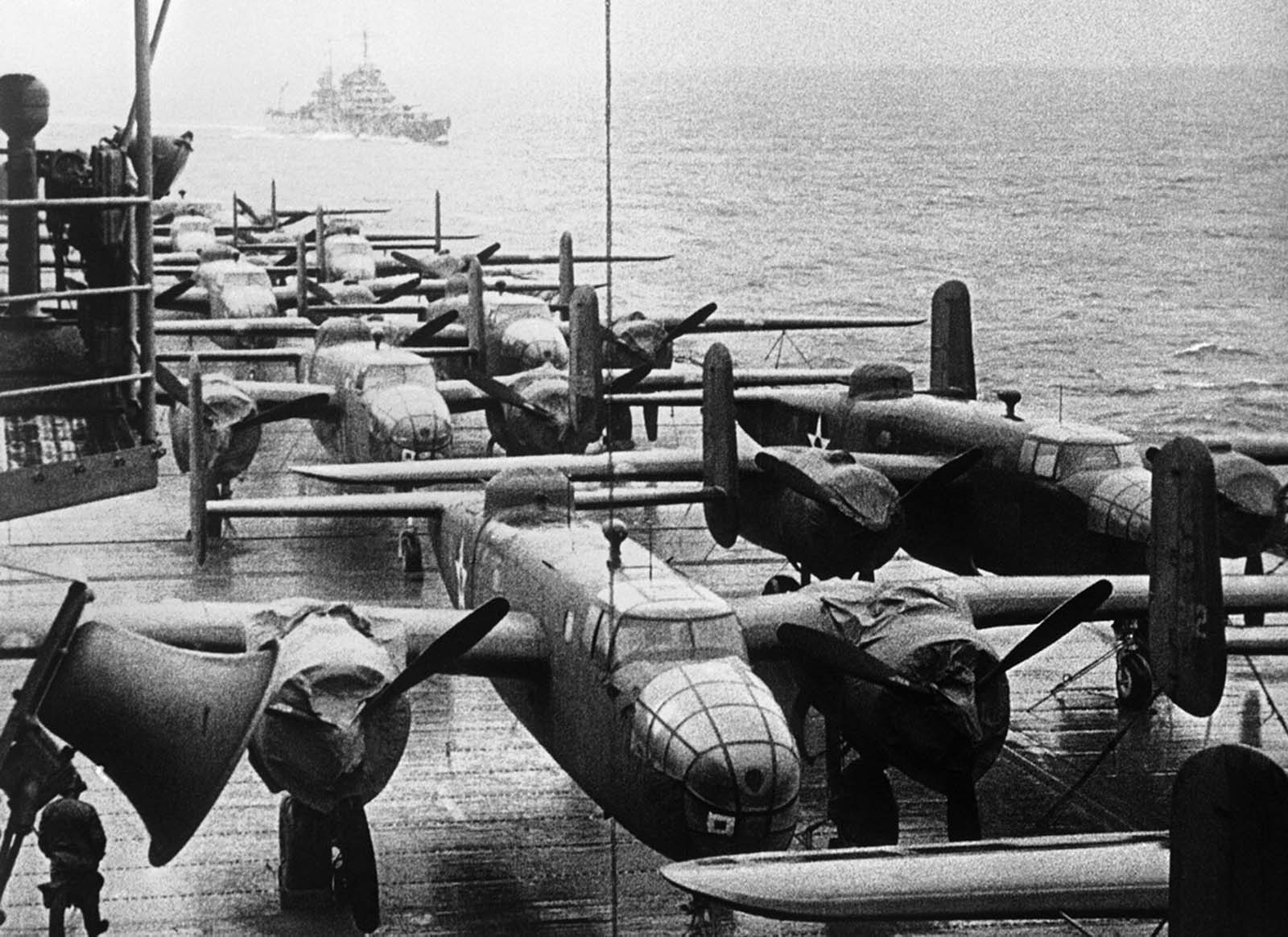 American B-25B bombers rest on the flight deck of the USS Hornet, approaching the spot where the planes were launched on their raid on Tokyo, April 13, 1942. Escort ship in left background.