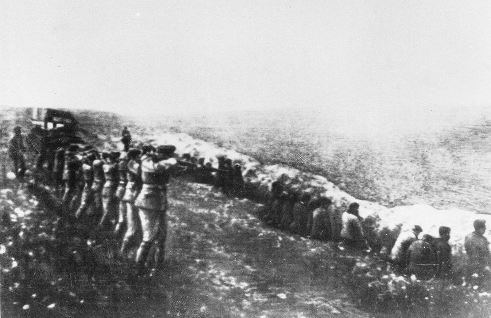 This photo was taken from a the body of a dead Germany officer killed in Russia, showing a German firing squad shooting Soviet civilians in the back as they sit beside their own mass grave in Babi Yar, an infamous ravine in the Ukrainian capital of Kiev, in 1942. Between 1941 and 1942, an estimated 100,000 to 150,000 Jews, Soviet prisoners, communists, gypsies, Ukrainian nationalists and civilians were executed by the Germans in Babi Yar.