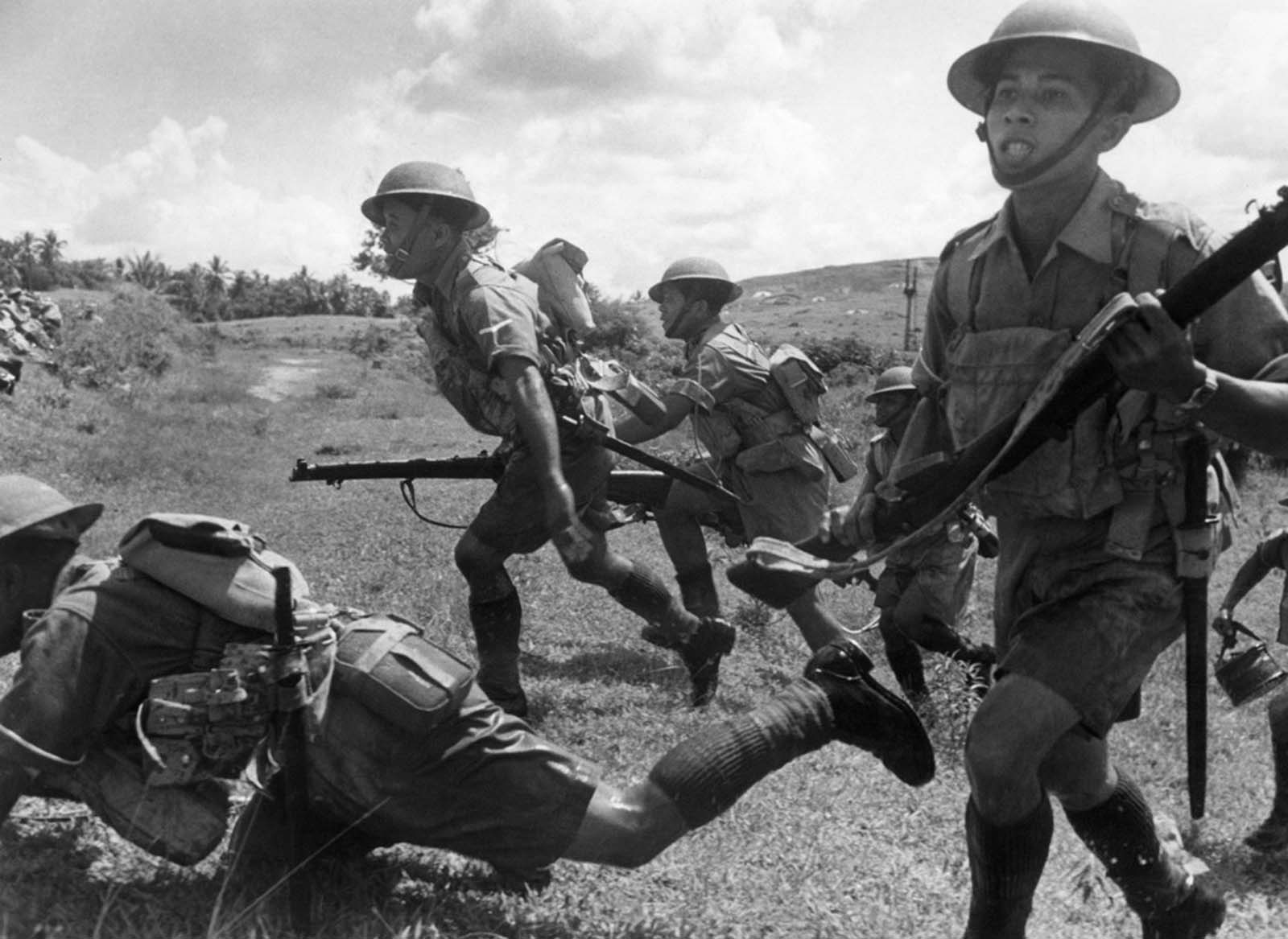 Malayan soldiers intent on defending their peninsula charge forward at a Malay battle zone on February 10, 1942, before the Japanese completed their occupation of the peninsula and pushed Britons back onto Singapore Island.
